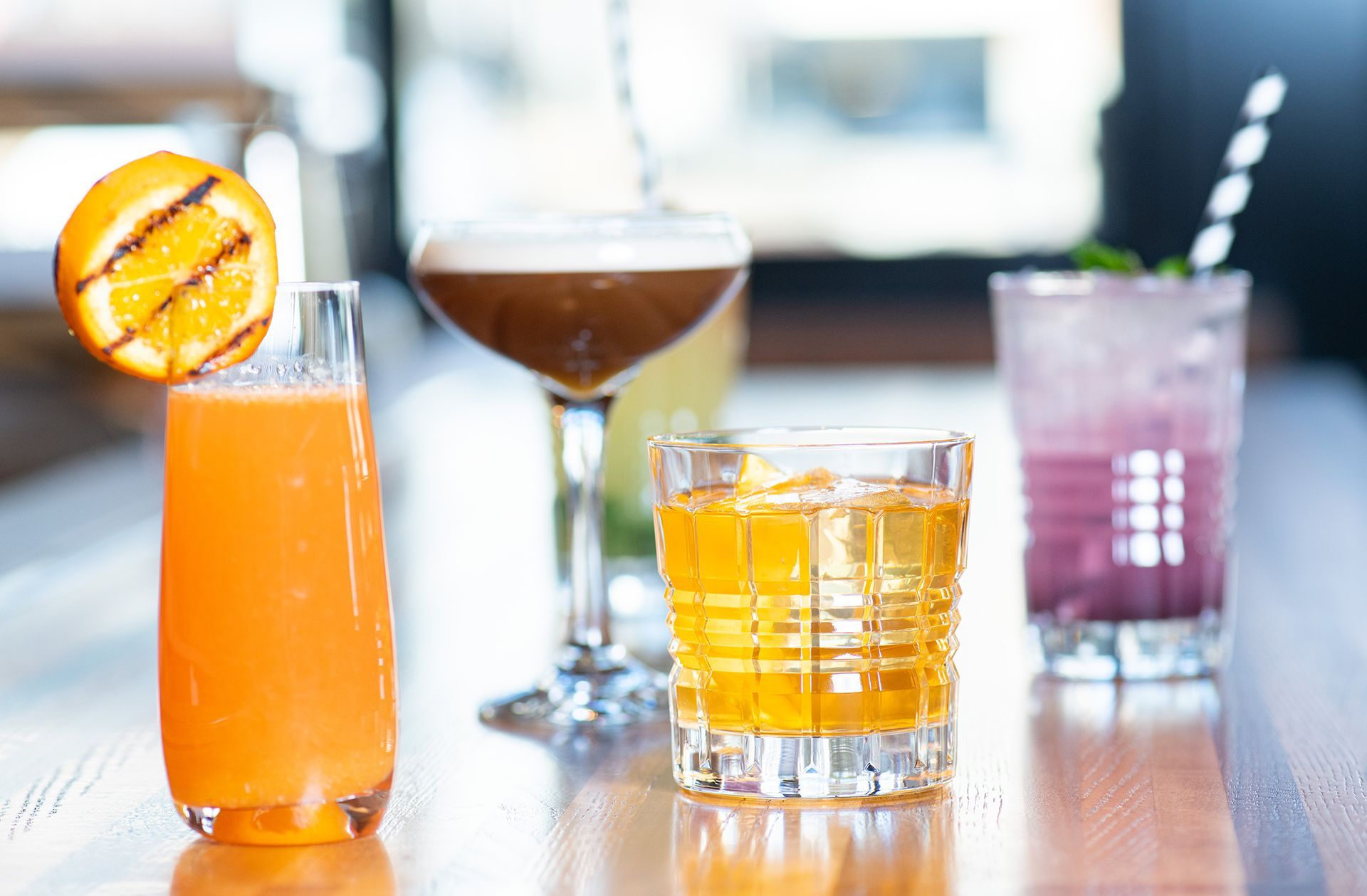 Three different types of drinks are sitting on a wooden table.