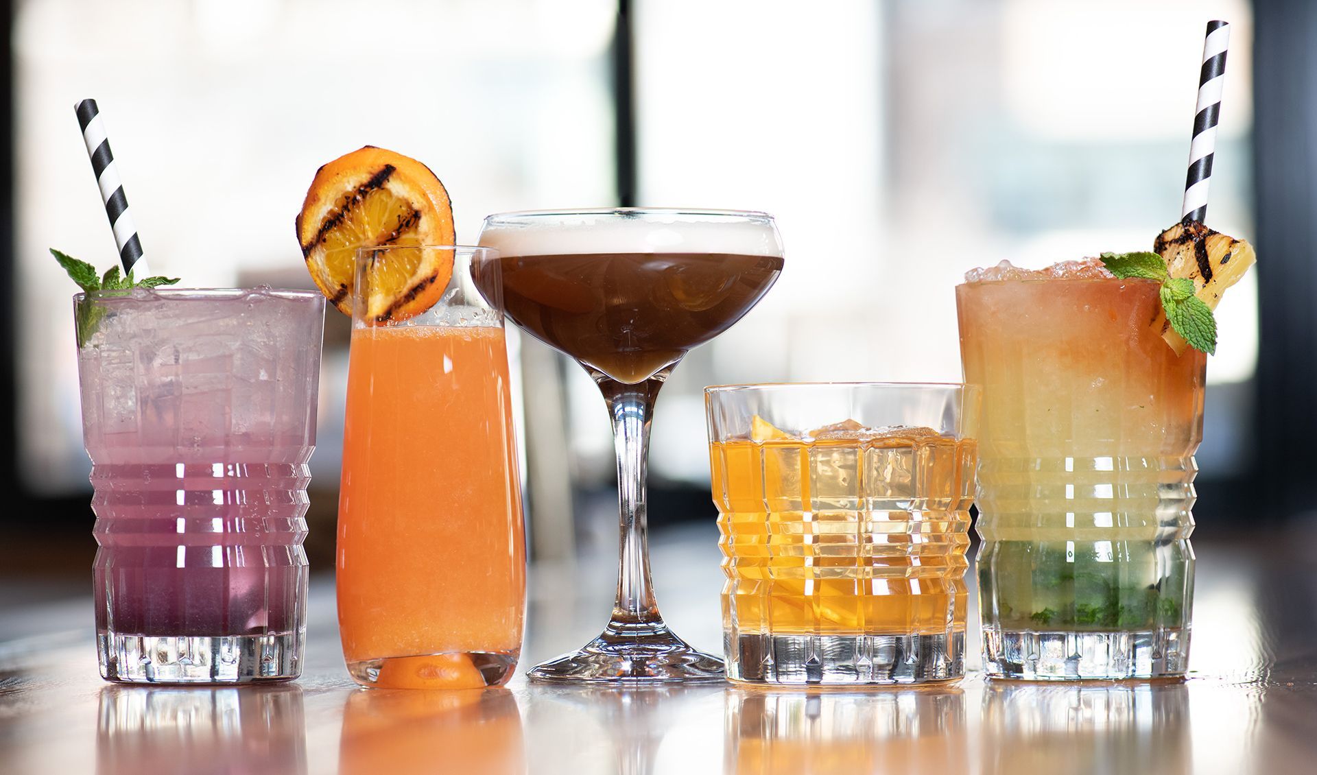 Four different types of drinks are sitting on a table.