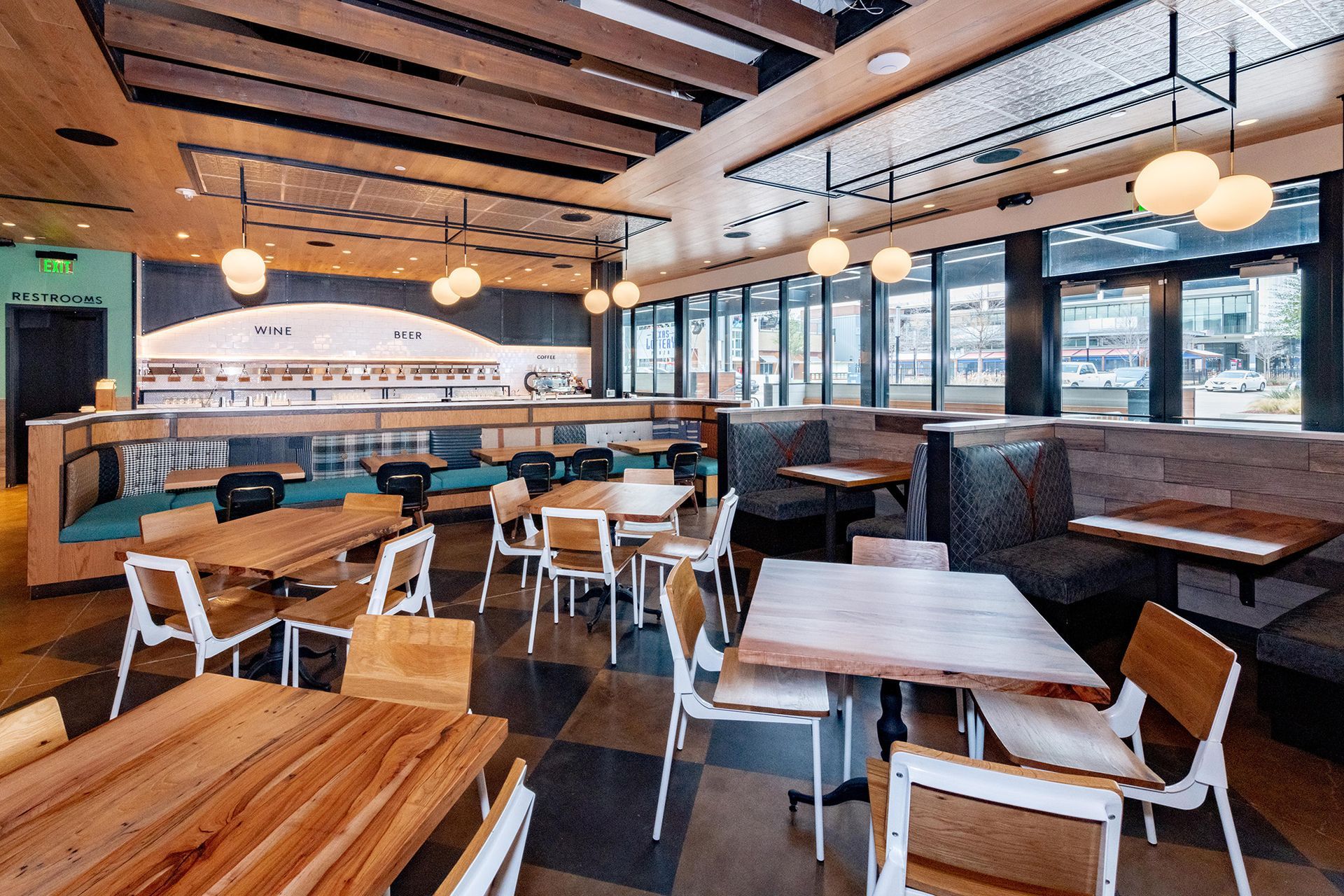 A restaurant with tables and chairs and a lot of windows.