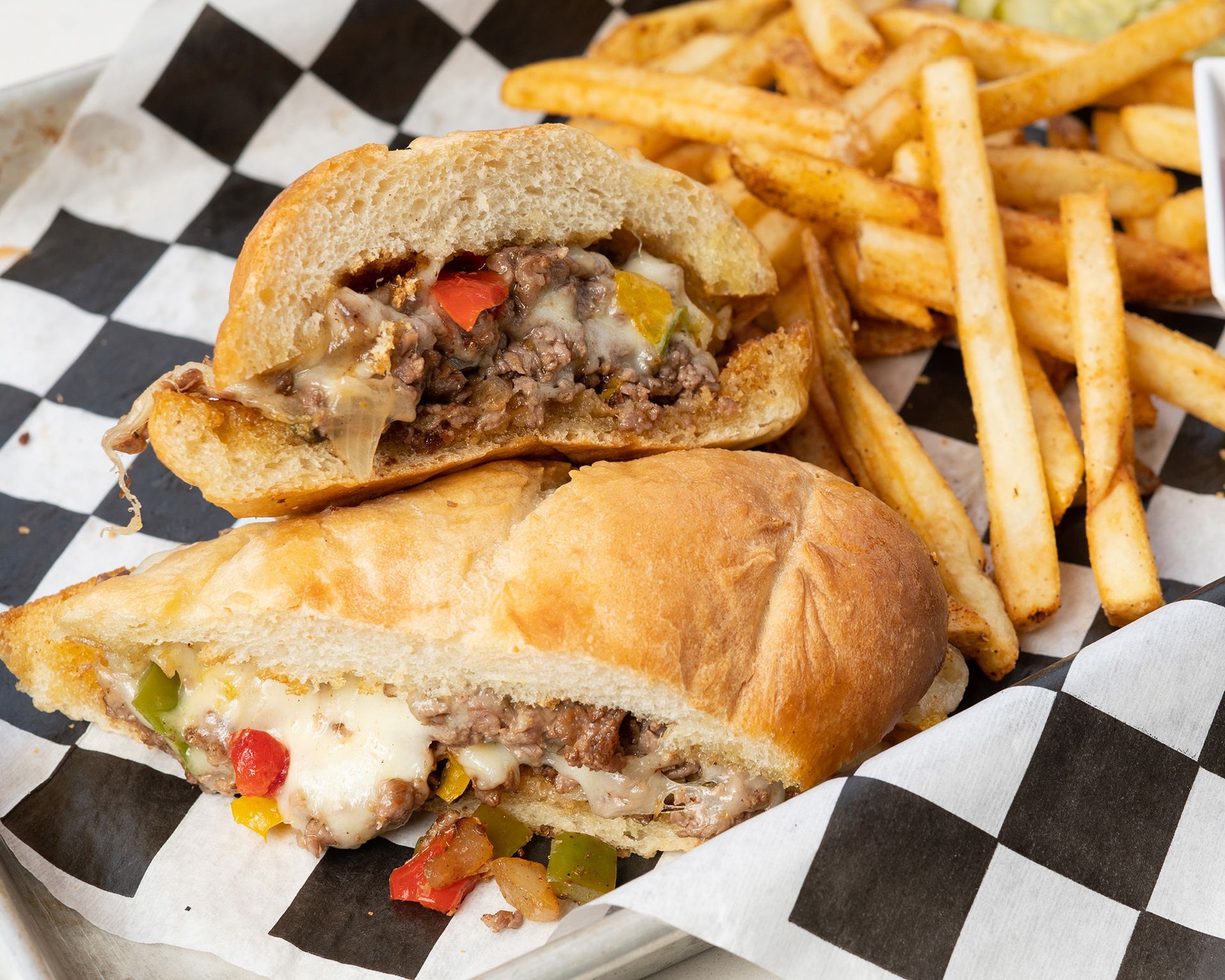 A sandwich and french fries on a checkered napkin
