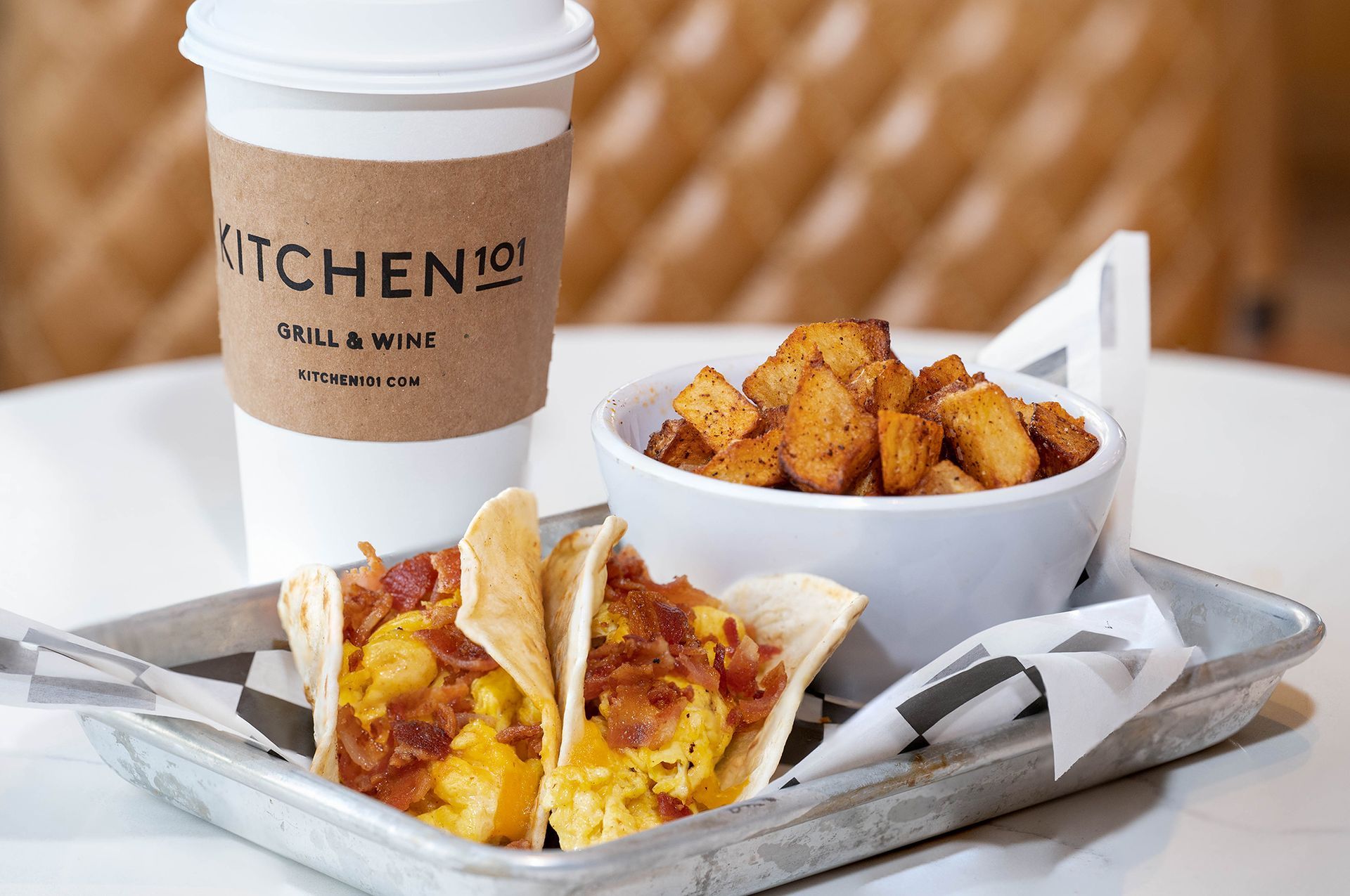 A tray of food and a cup of coffee on a table.