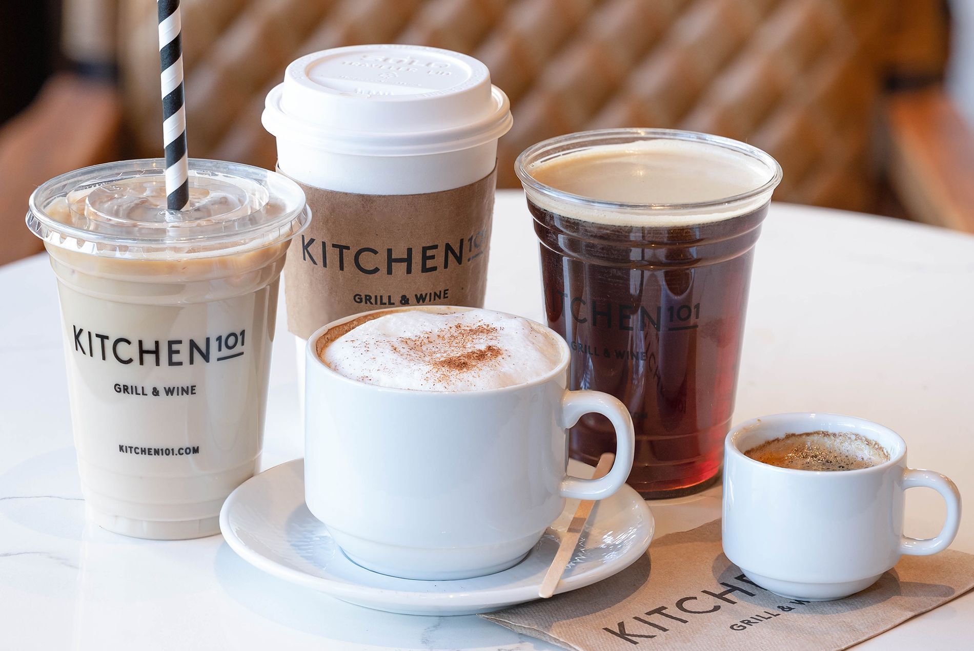 Four cups of coffee are sitting on a table.