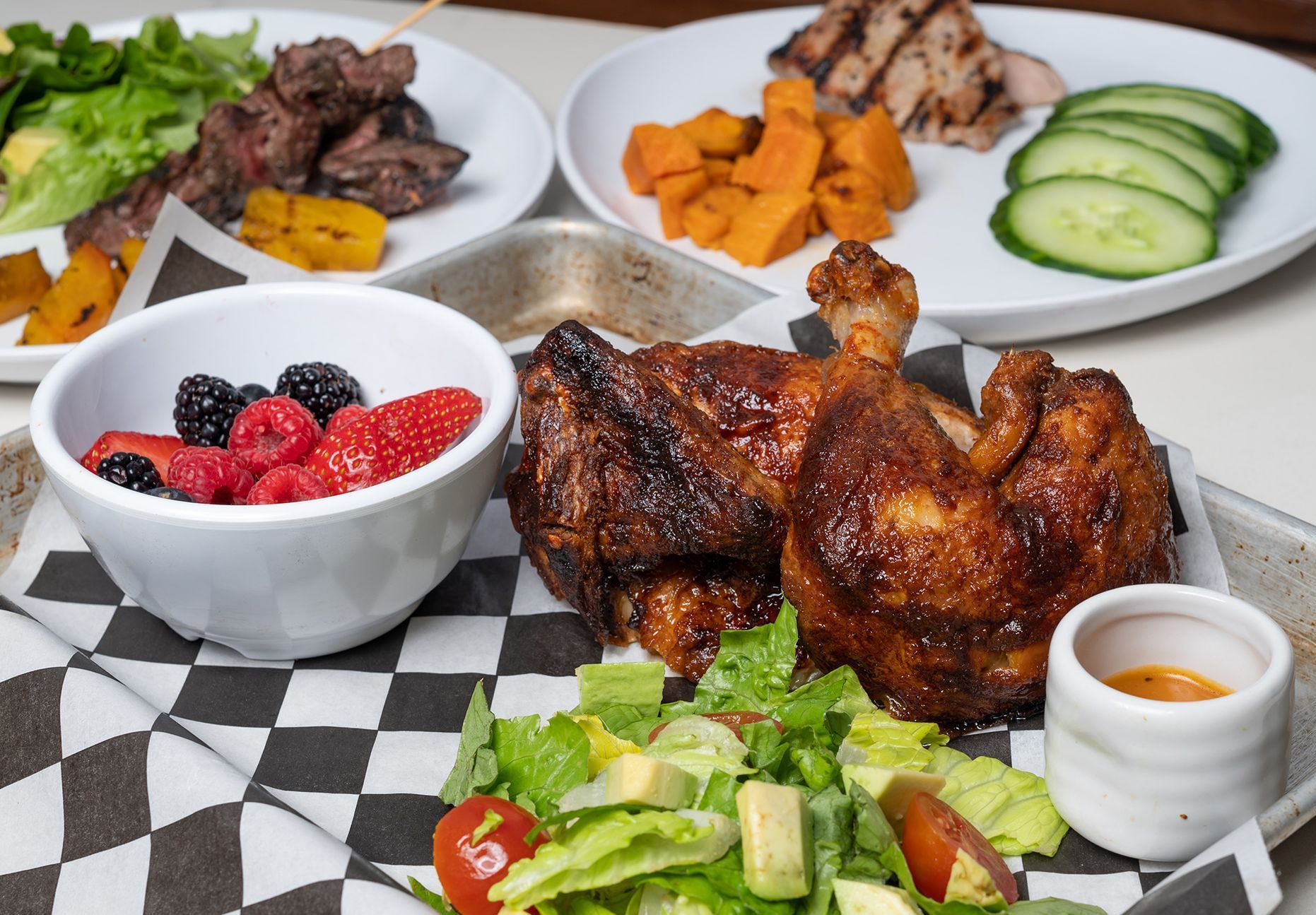 A table topped with plates of food and a bowl of fruit