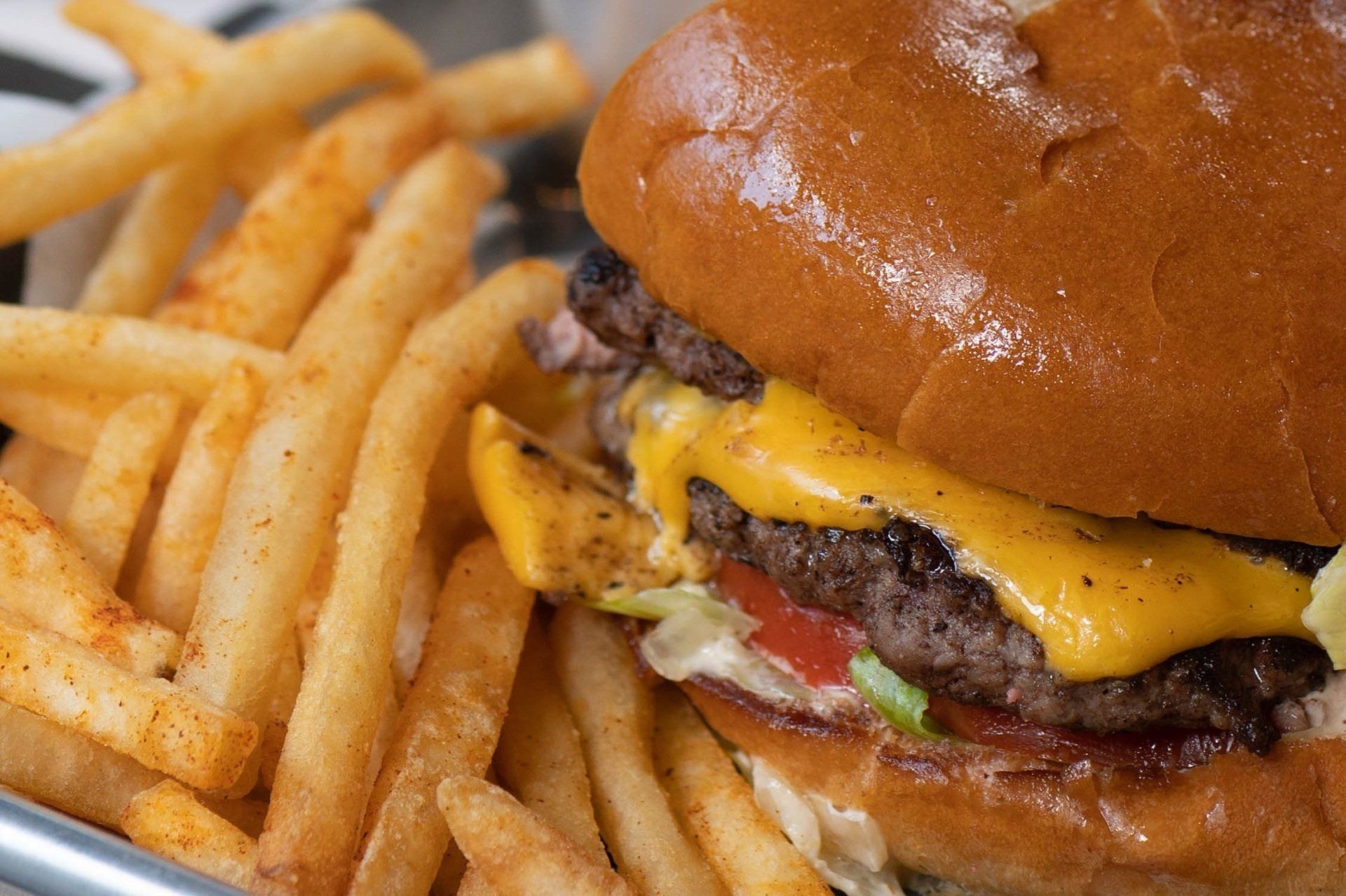 A close up of a hamburger and french fries on a plate.