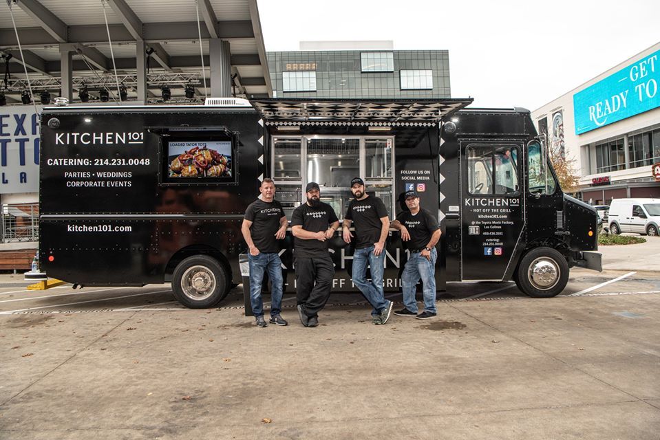 A group of men are standing in front of a food truck.