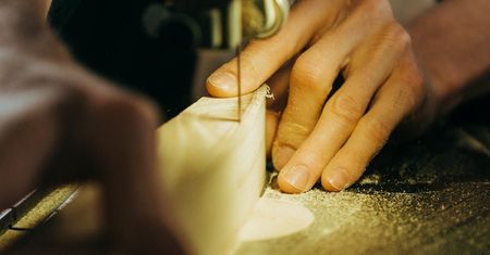 A person is cutting a piece of wood with a saw.