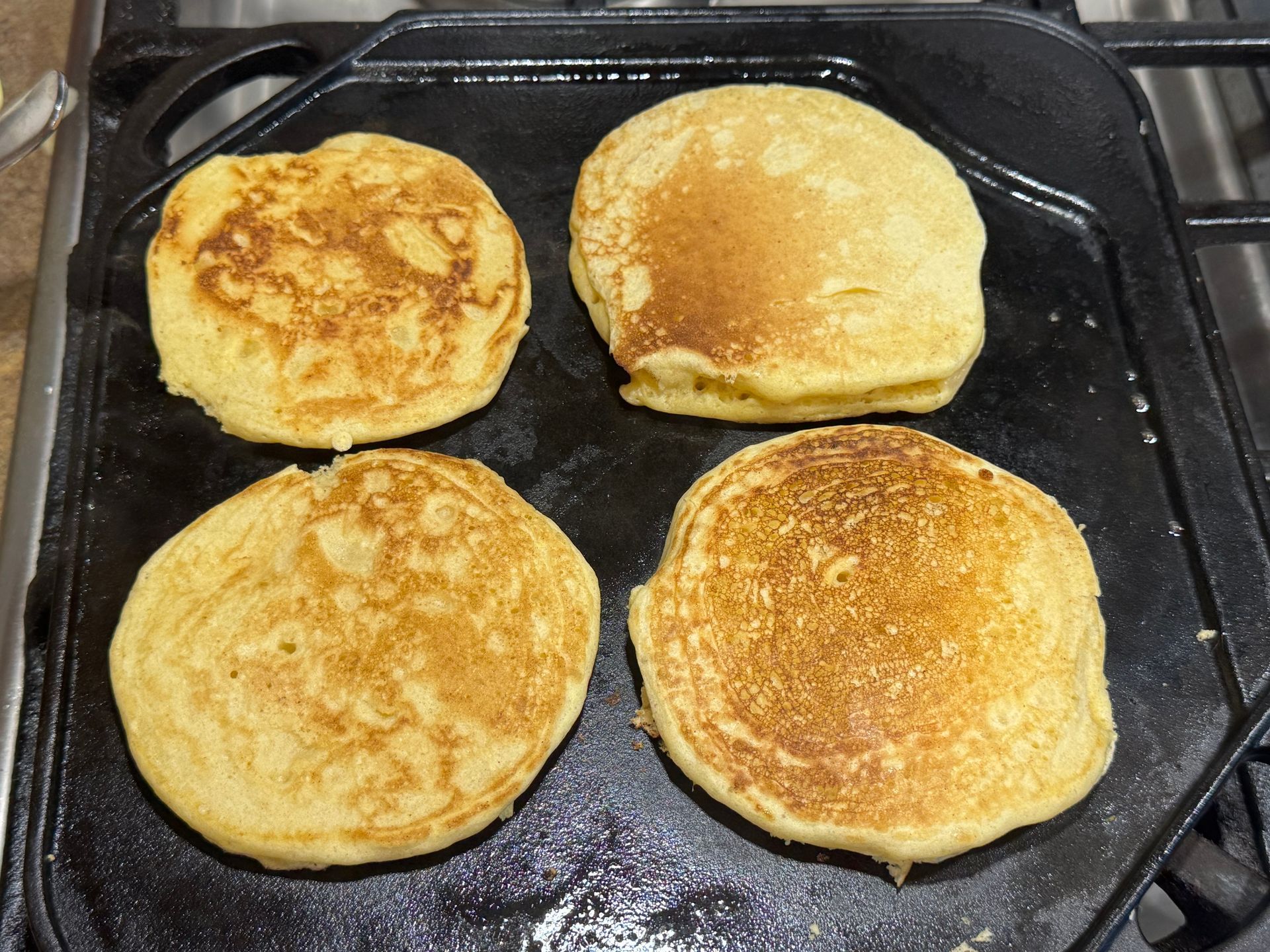Two pancakes are sitting on a white plate.