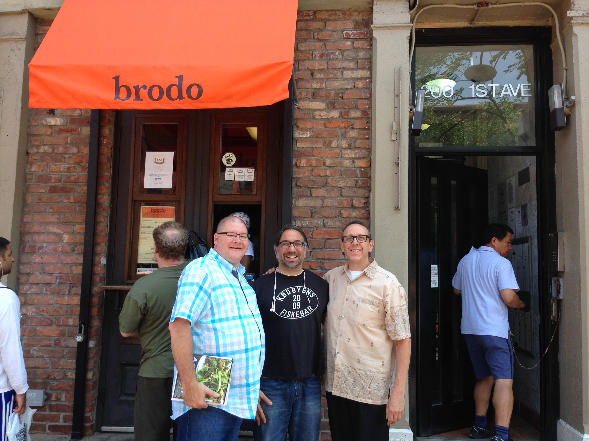 A group of men standing in front of a brodo restaurant