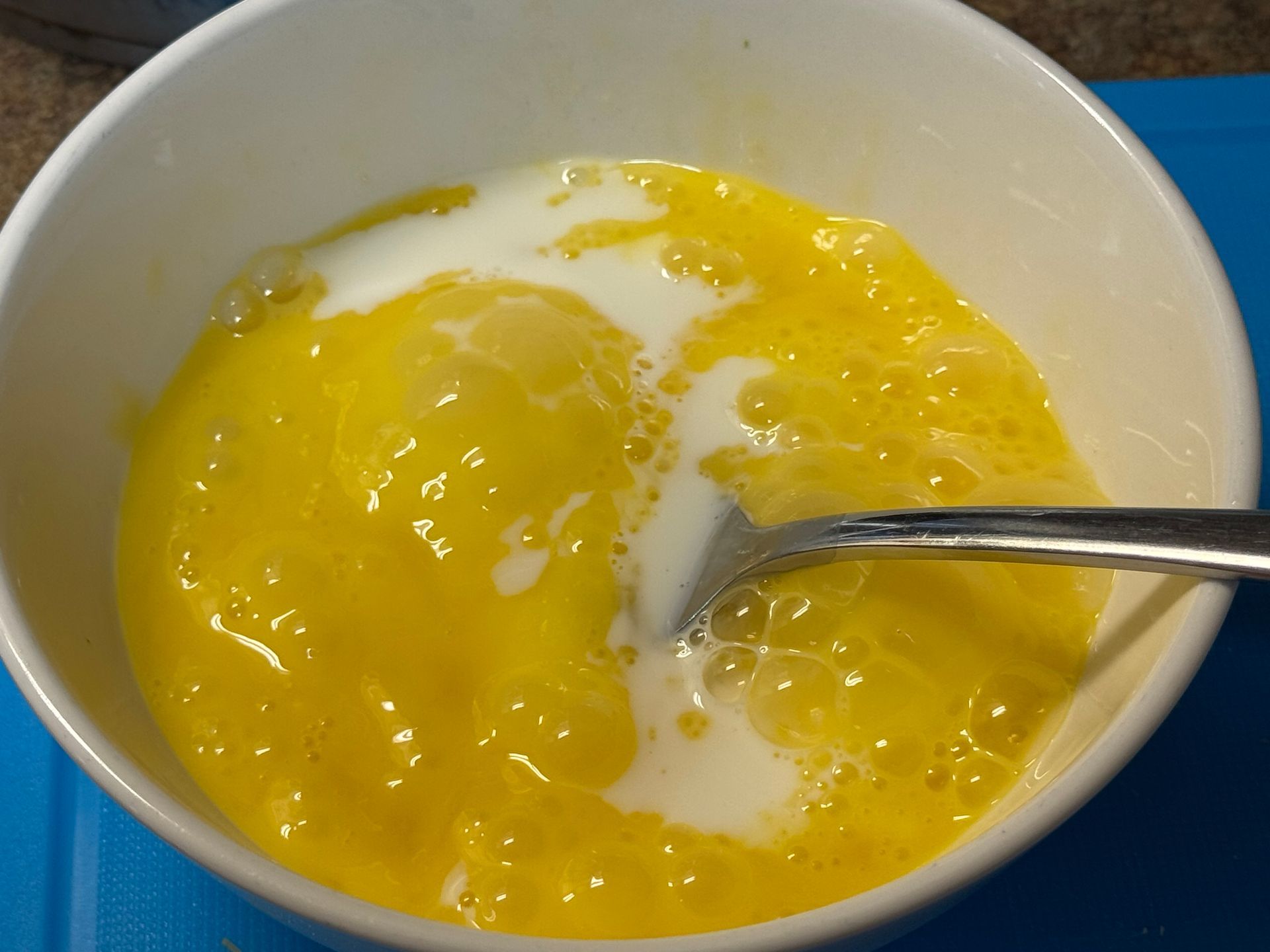 A close up of a tortilla with meat and rice on a cutting board.