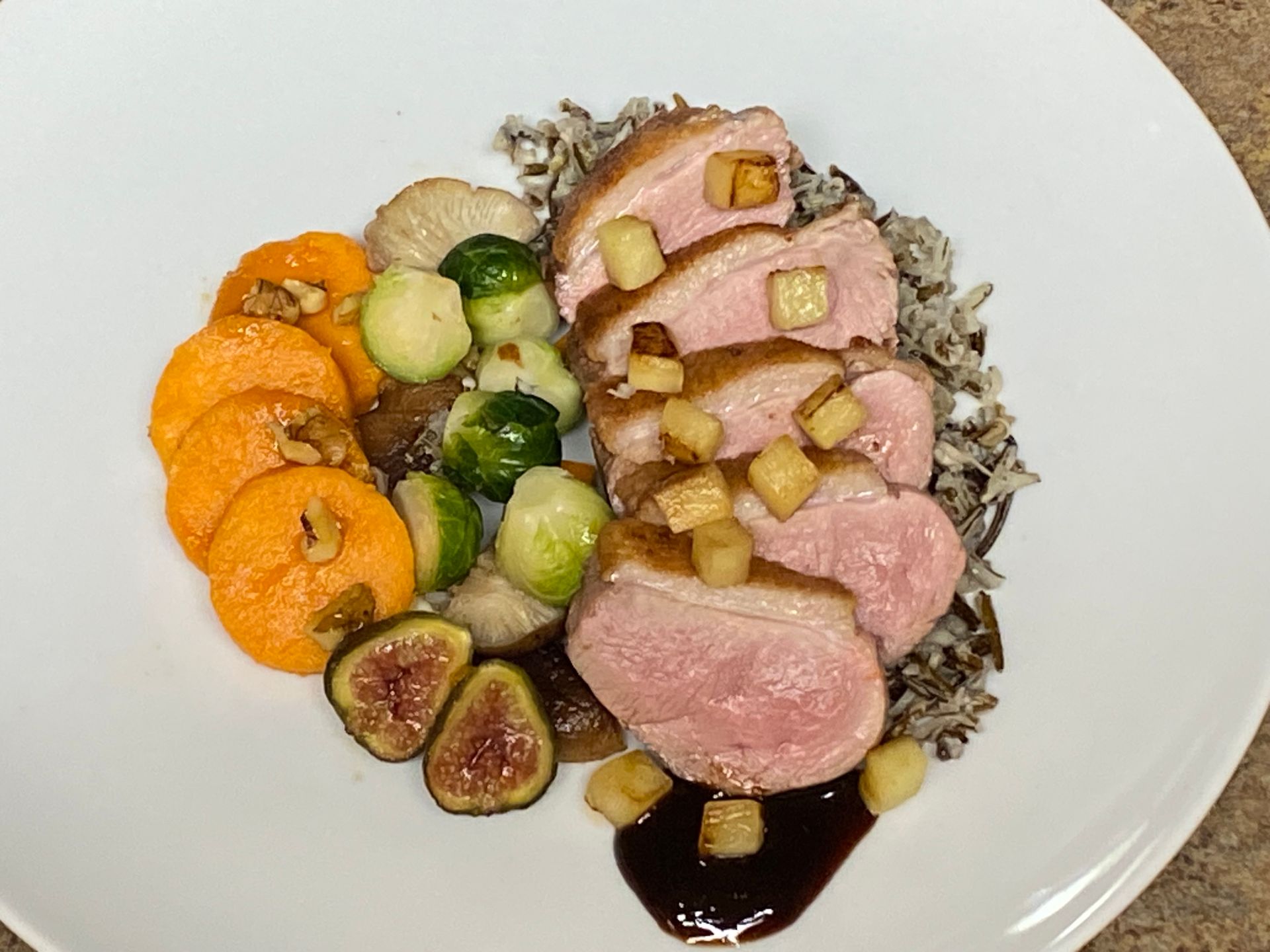 A white plate topped with meat rice and vegetables
