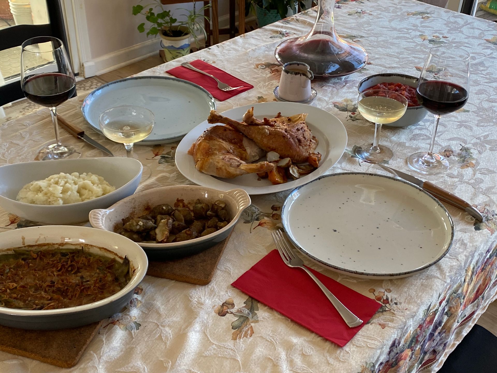 A table topped with plates of food and wine glasses.