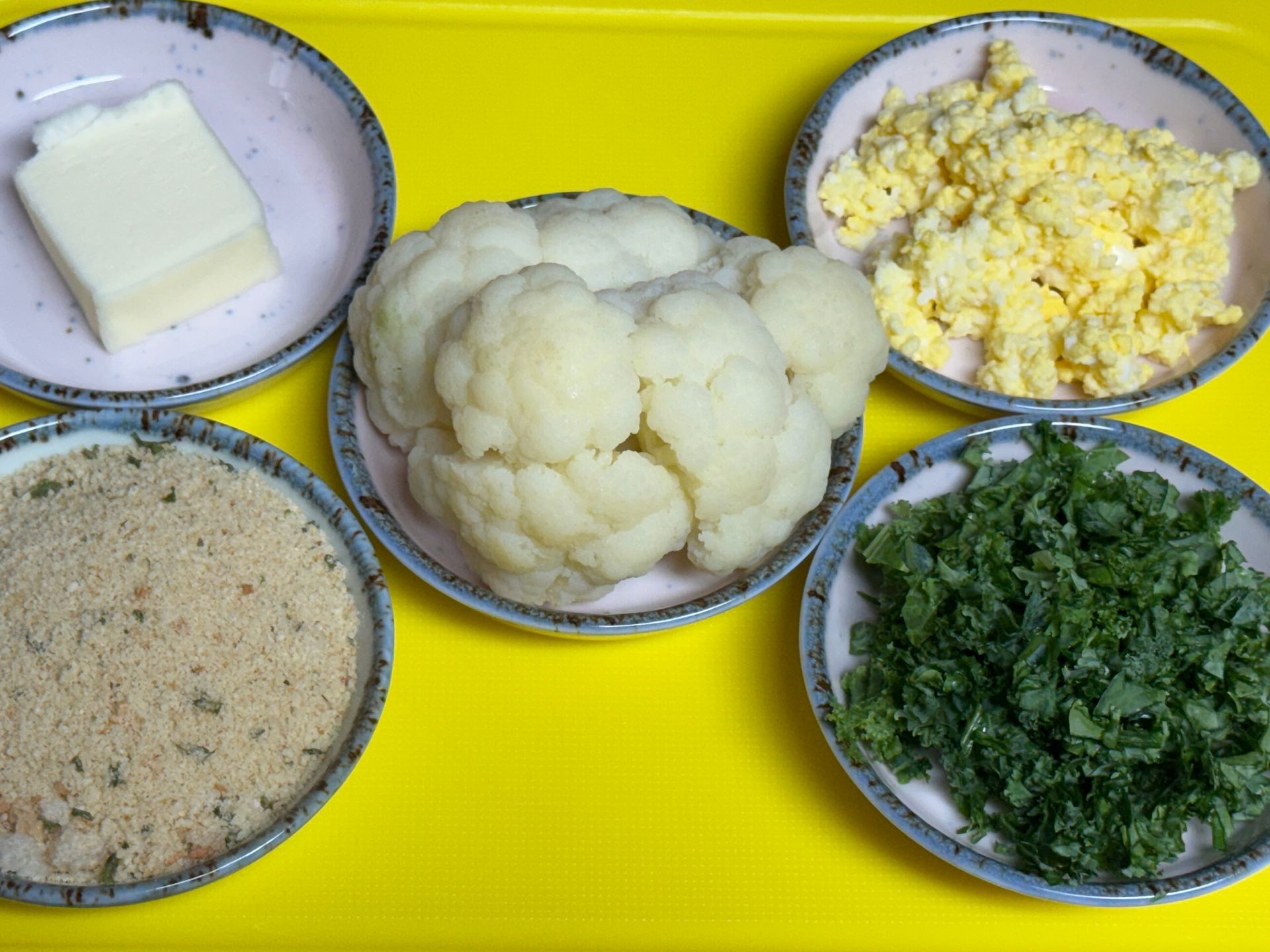 A close up of a white cauliflower with green leaves