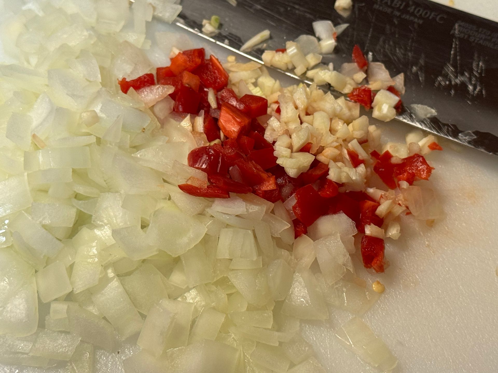 Chopped celery onions and potatoes on a cutting board