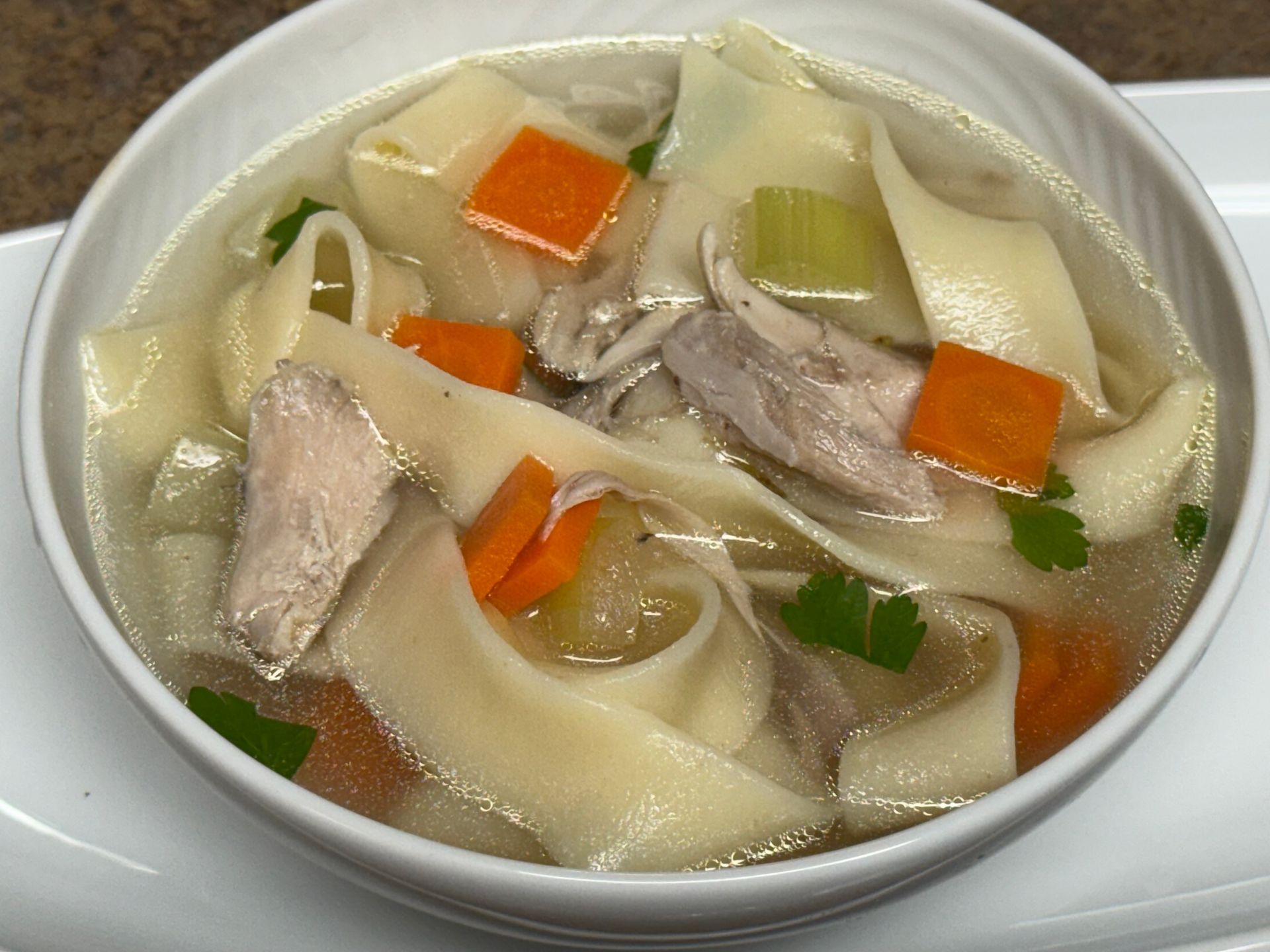 A close up of a bowl of soup with shrimp and potatoes.