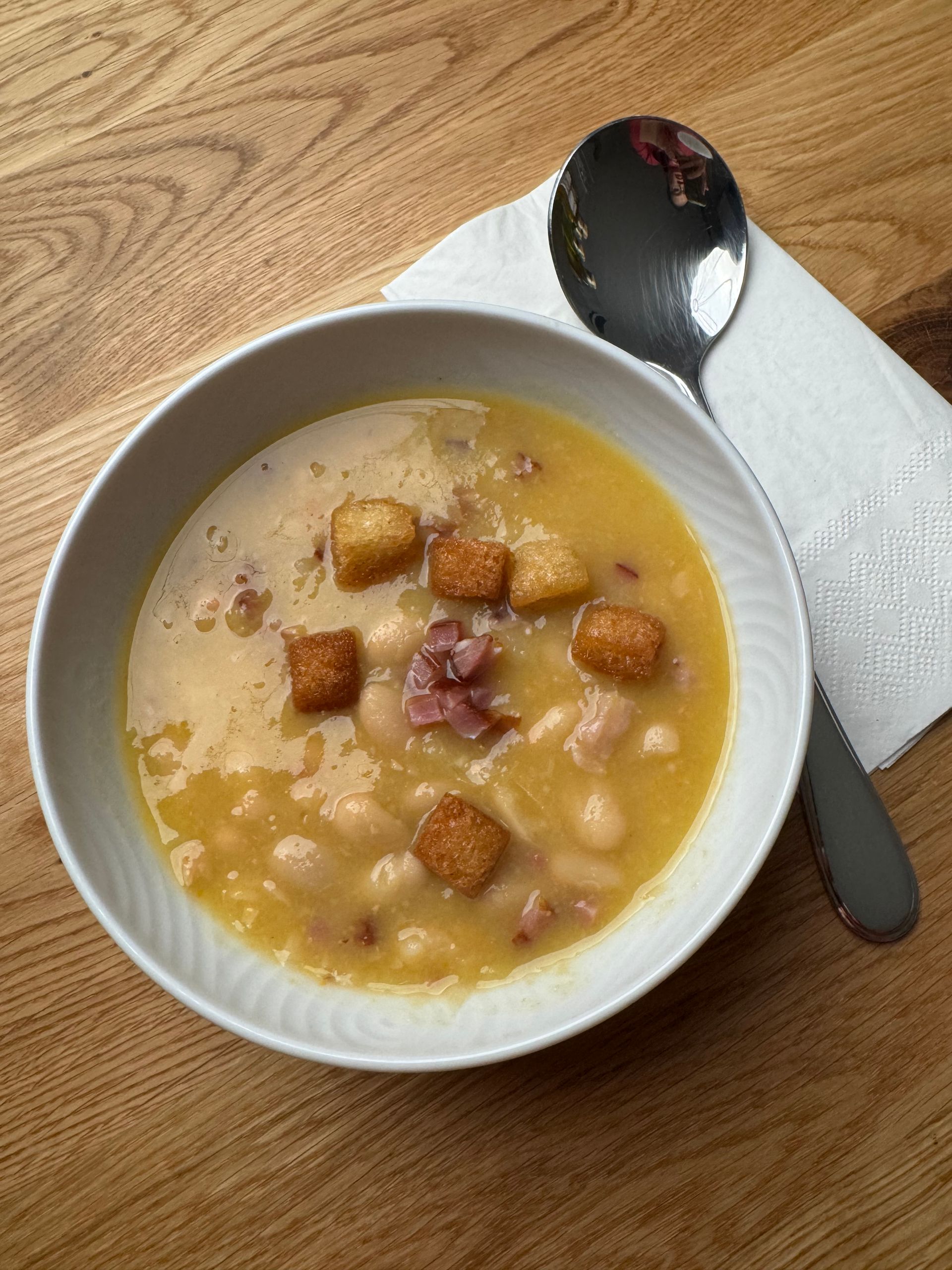 A close up of a bowl of soup with shrimp and potatoes.