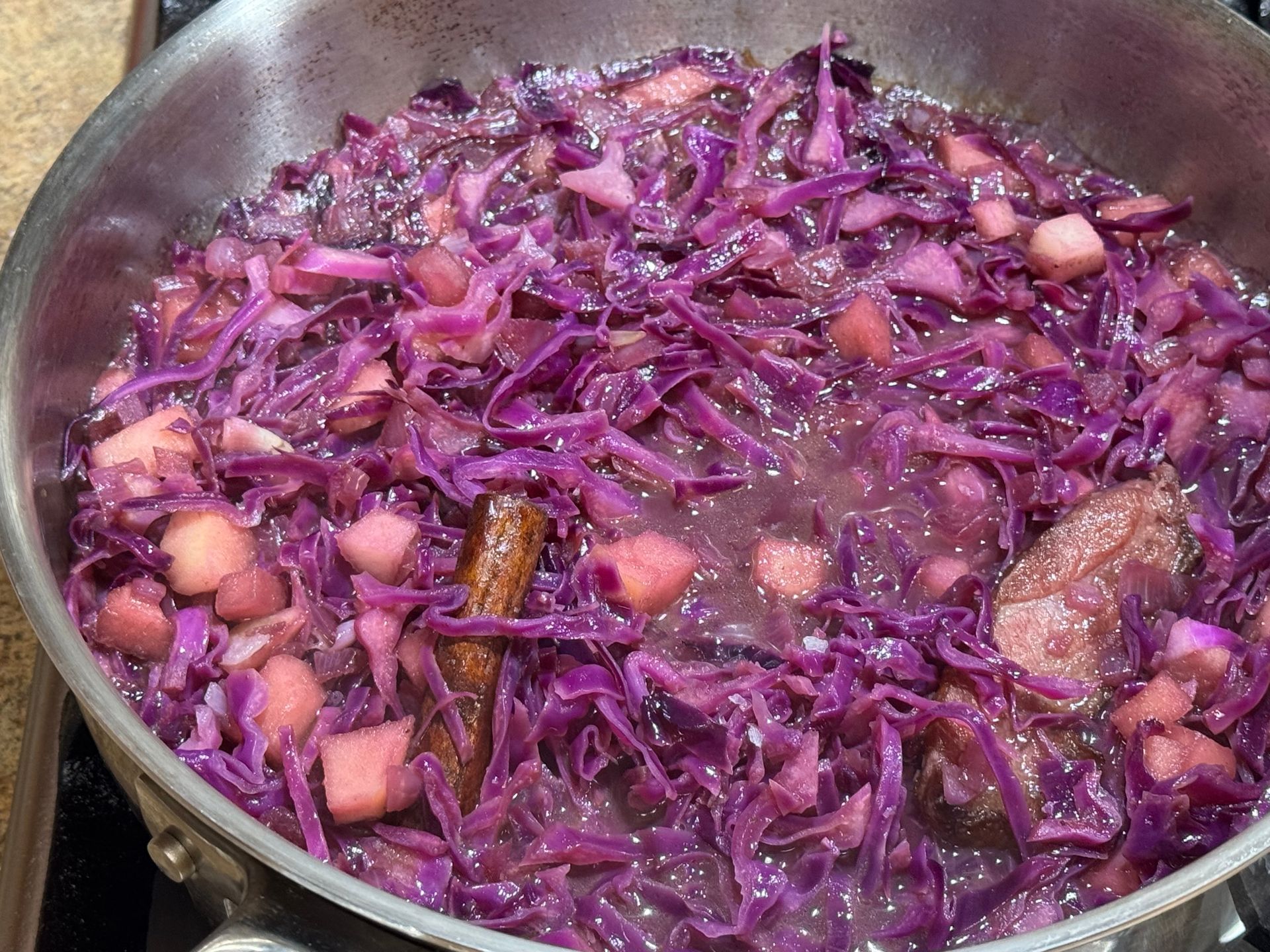 Brussels sprouts are being scooped out of a bowl of water with a ladle.