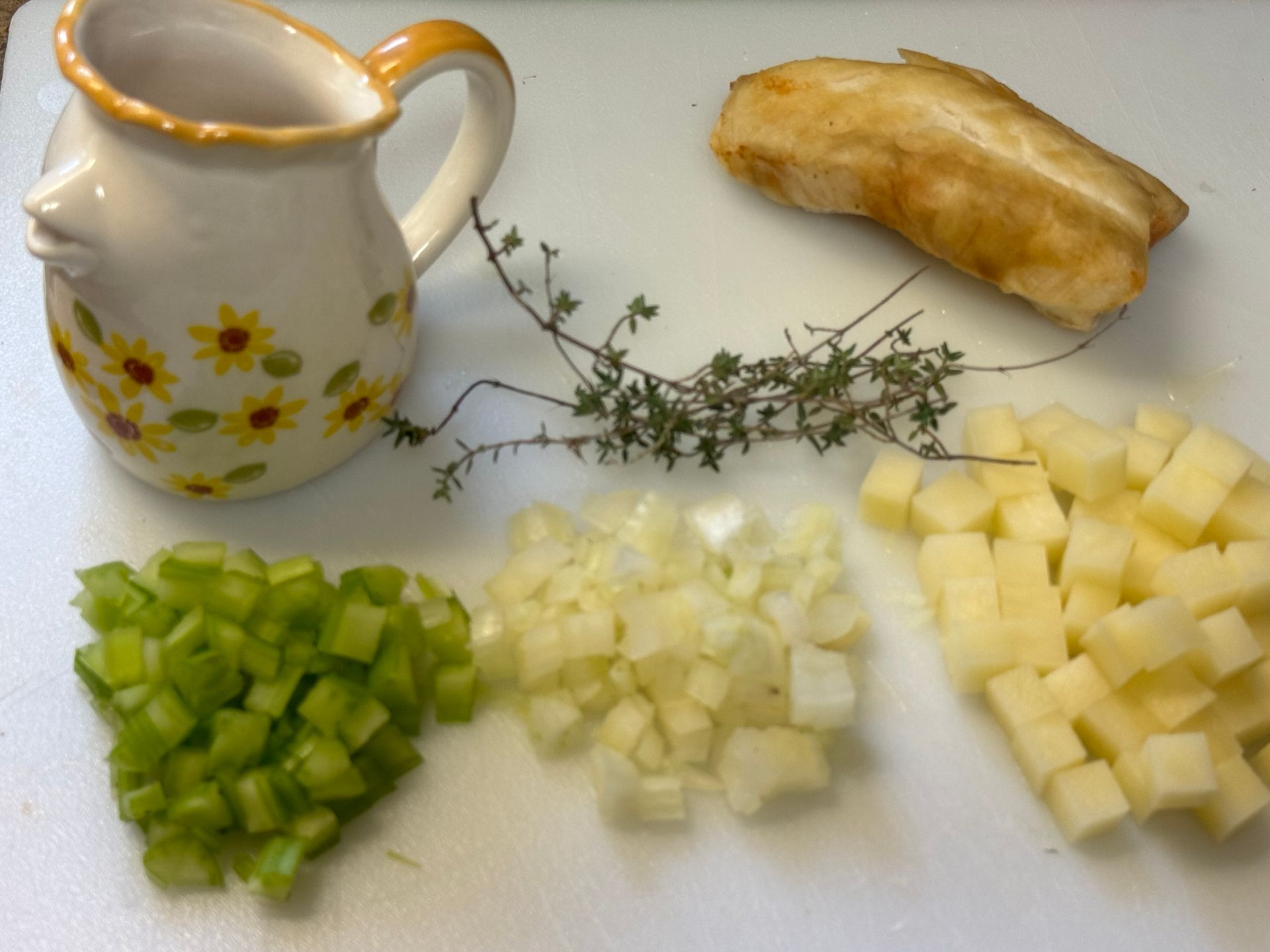 Chopped celery onions and potatoes on a cutting board