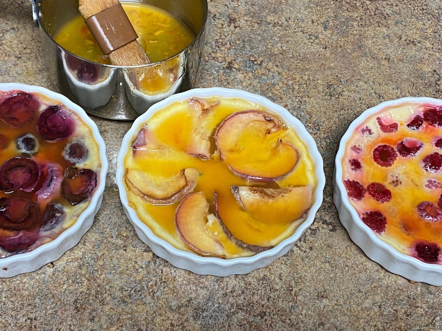 Three desserts are sitting on a table with a measuring cup in the background.