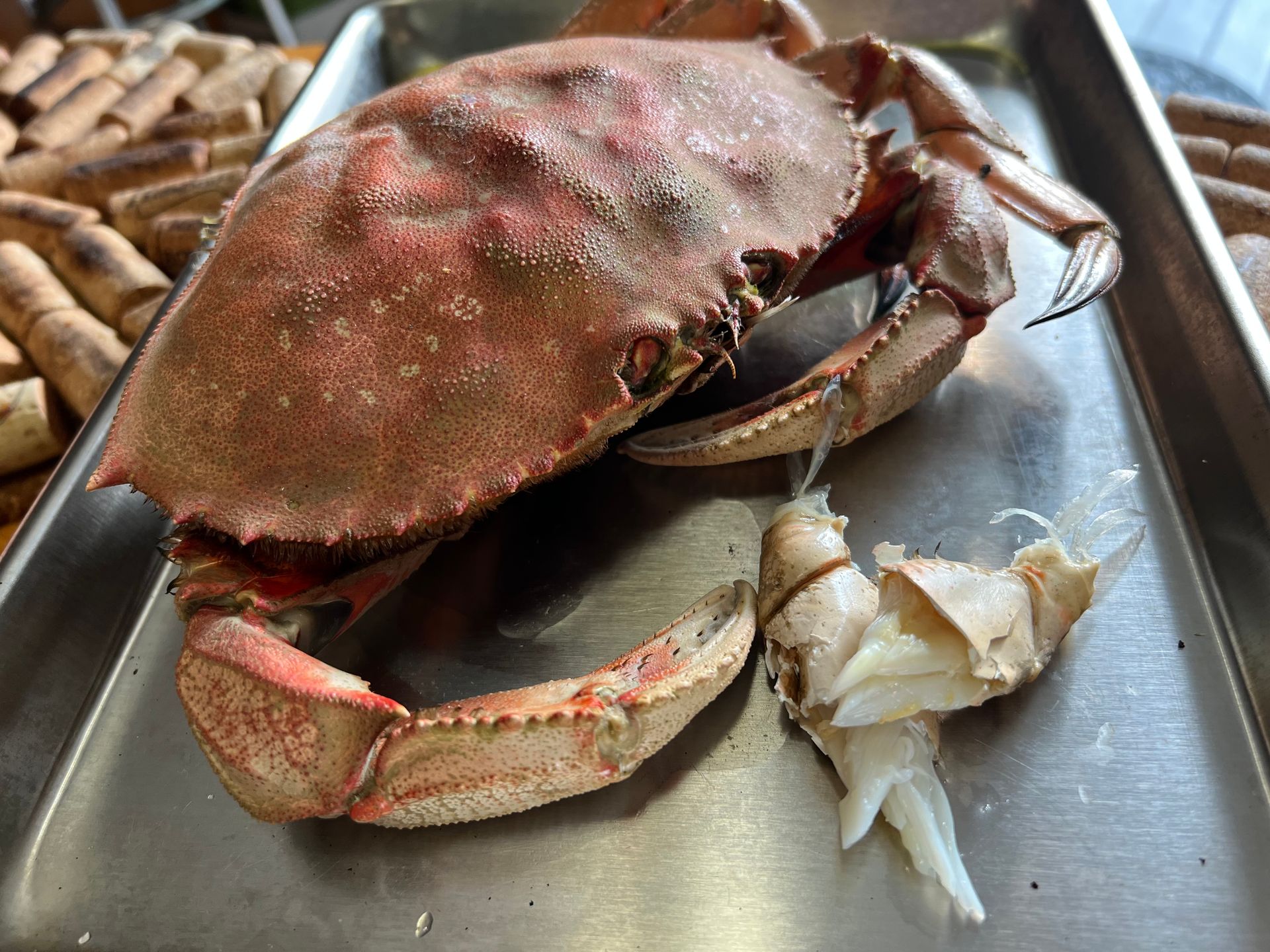 A large crab is sitting on top of a metal tray.