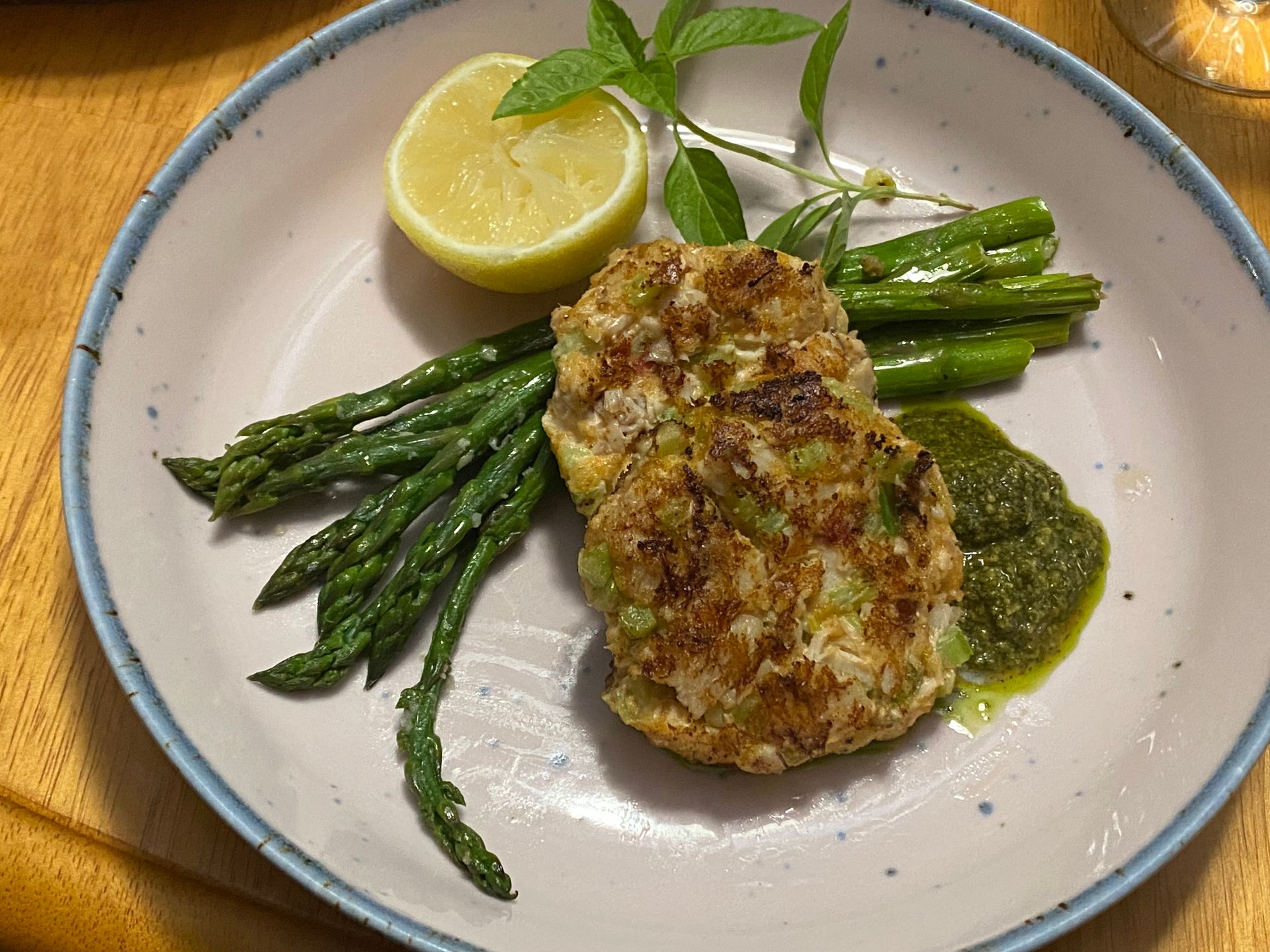 A plate of food with asparagus and a lemon on a table.