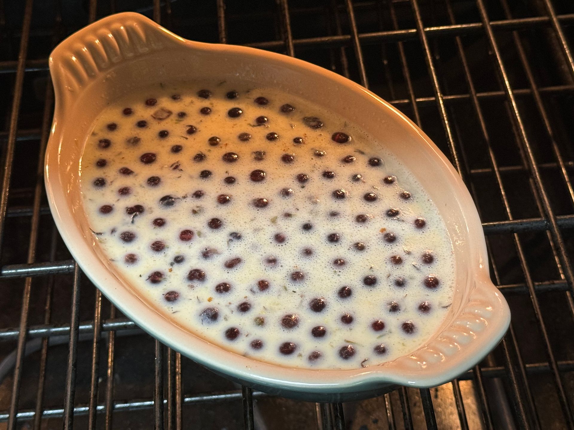 A casserole dish with blueberries in it is sitting on a grill