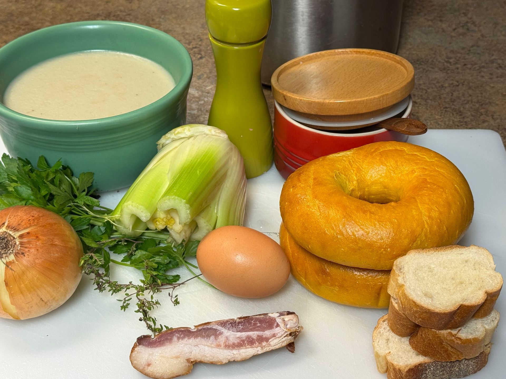 A cutting board with eggs , apples , celery , onions and croutons on it