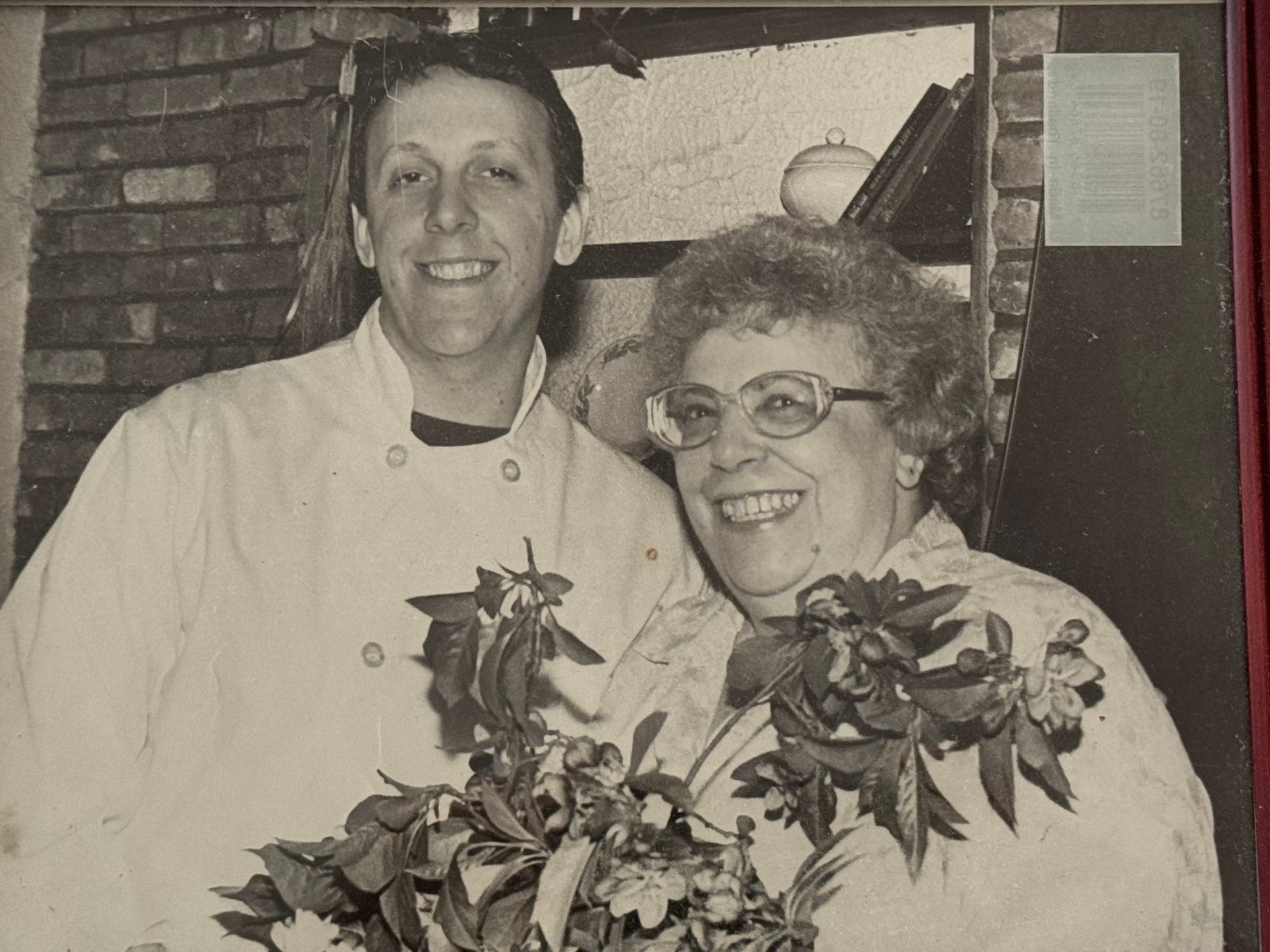 A black and white photo of a man and woman holding flowers