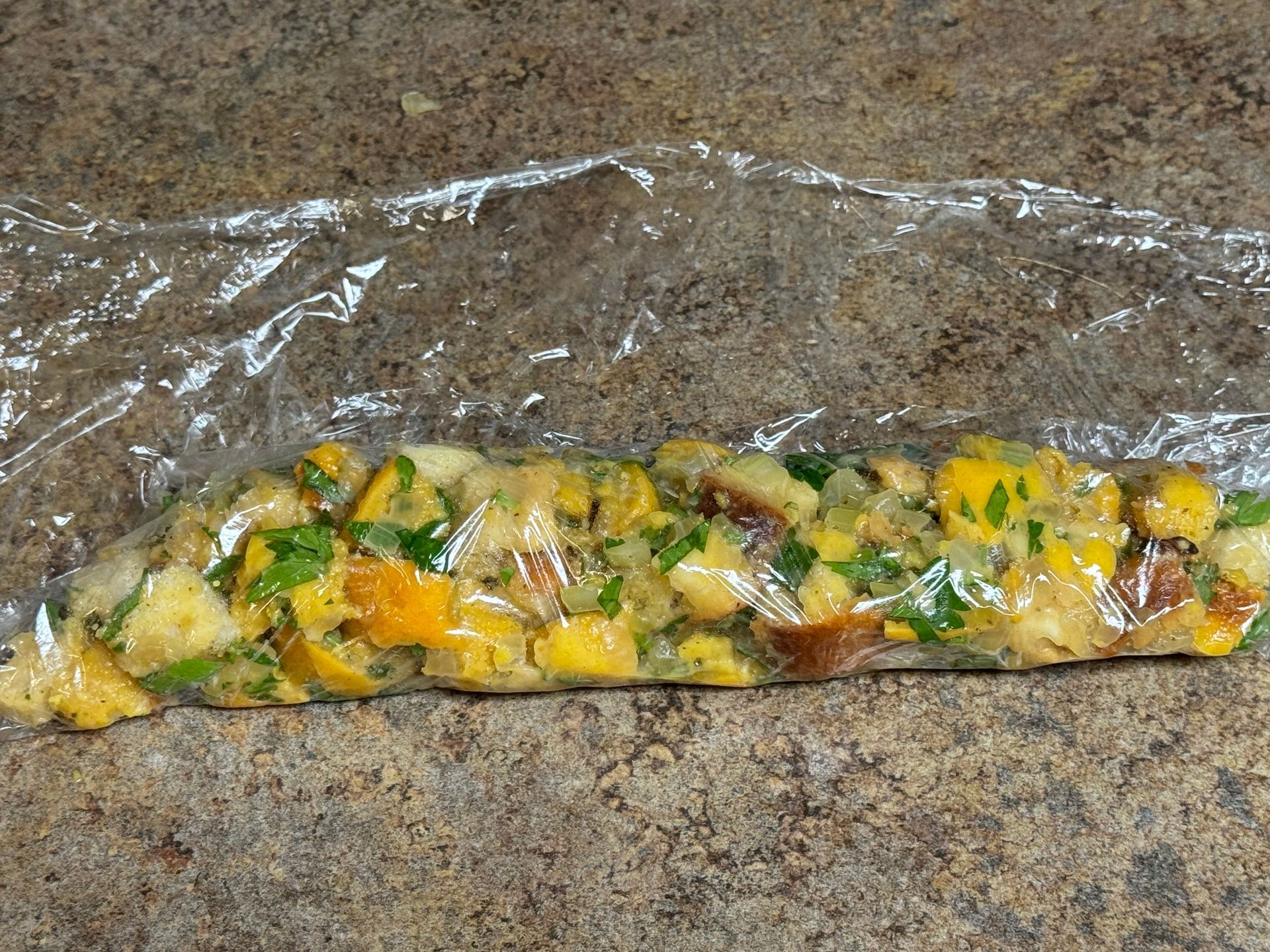 A glass casserole dish filled with stuffing and apples.