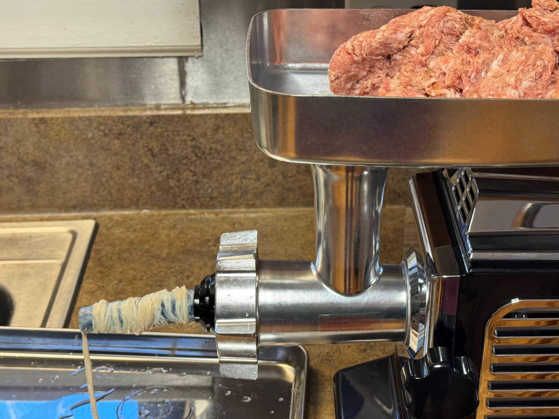 A row of sausages wrapped in plastic next to a pair of scissors