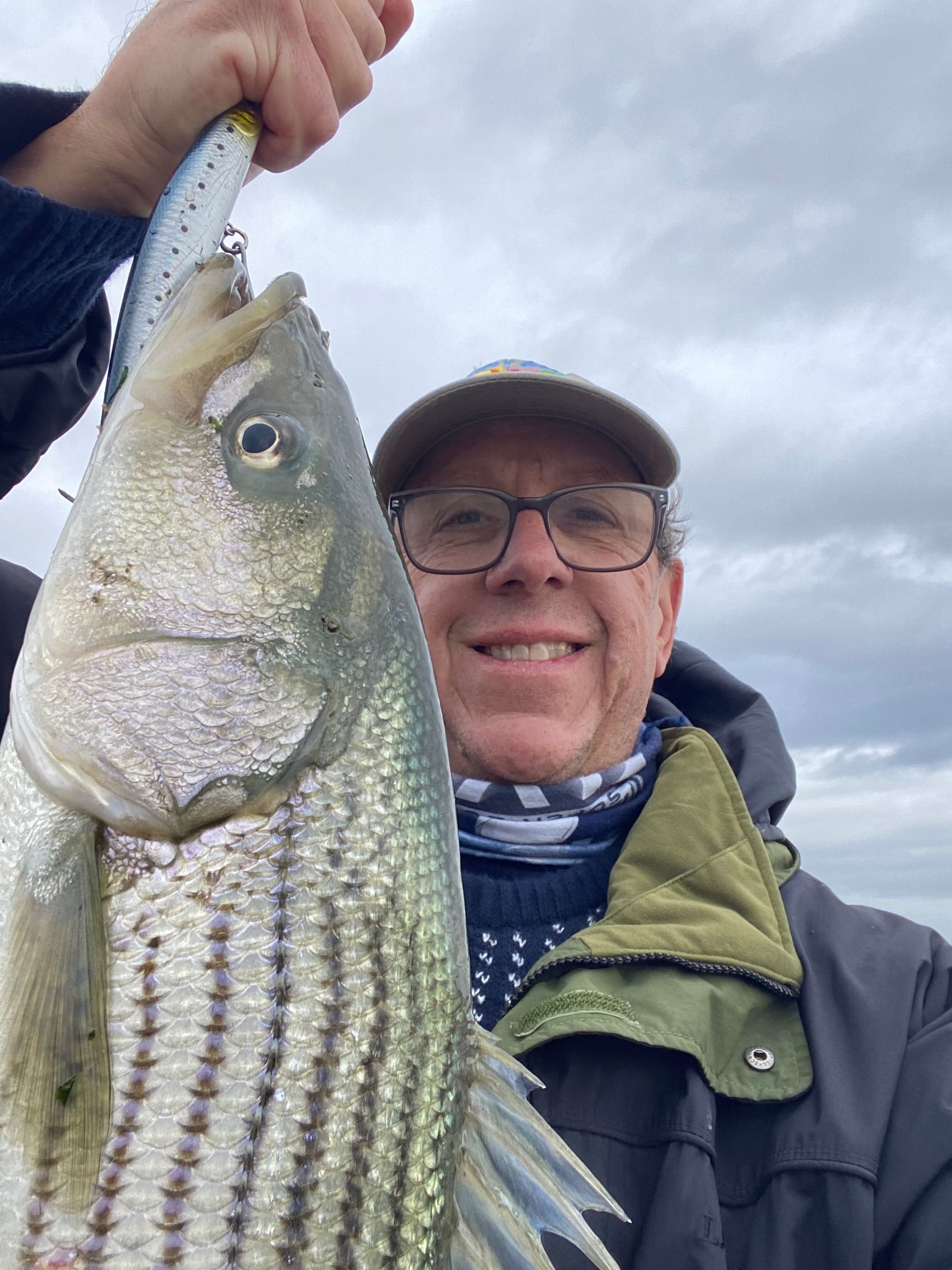 A man is holding a large fish in his hand.