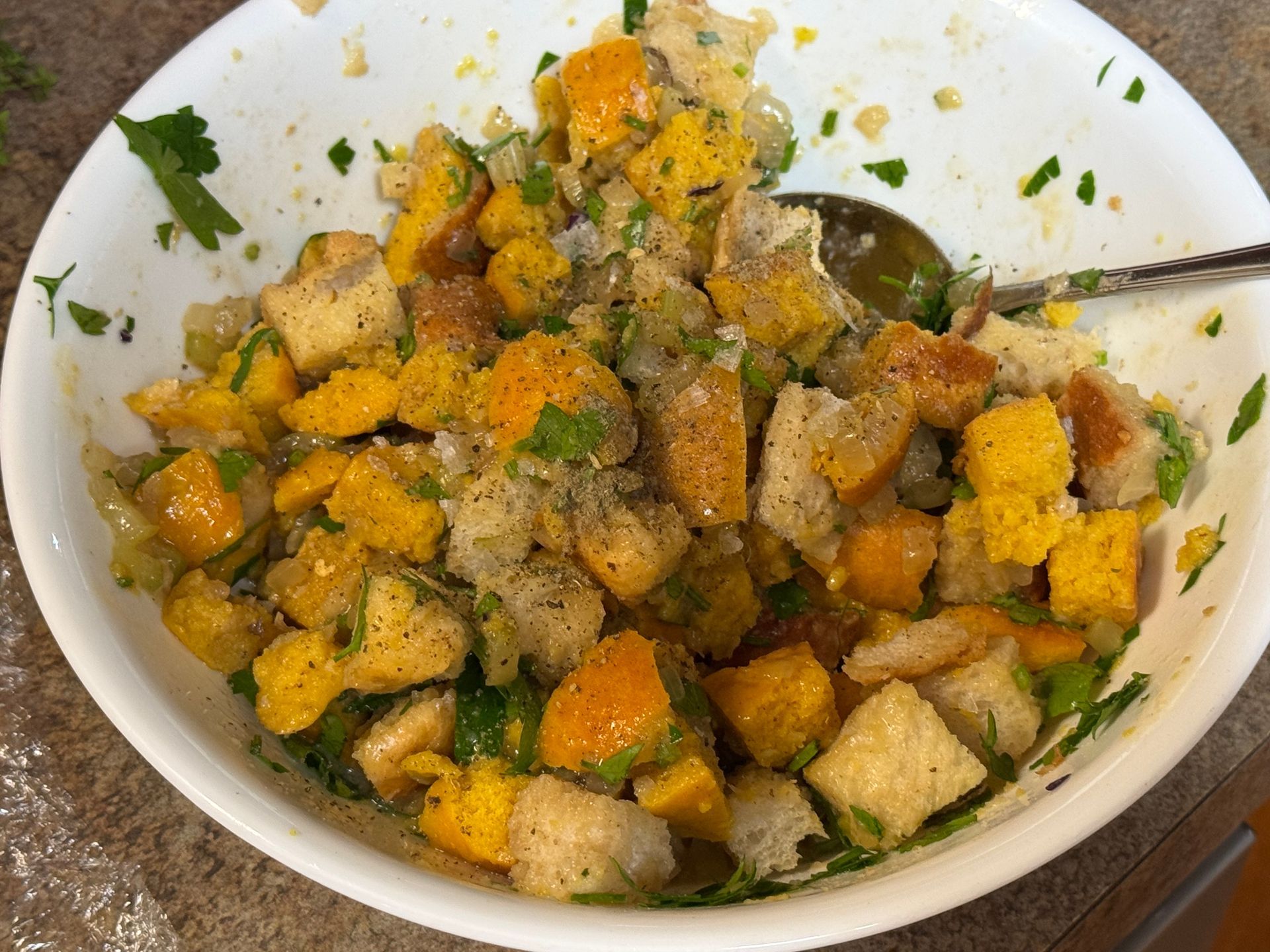 A close up of a bowl of stuffing with bread and vegetables.