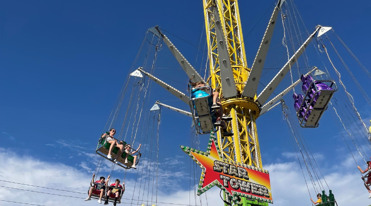 A group of people are riding a ferris wheel at an amusement park.