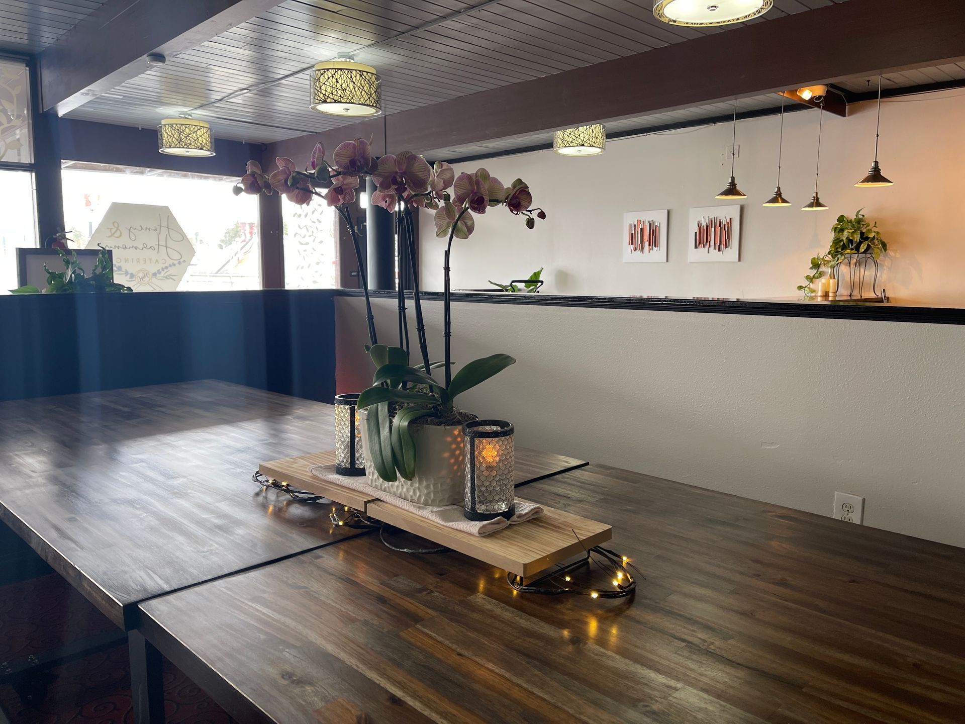 Wooden table with orchid centerpiece in a restaurant.