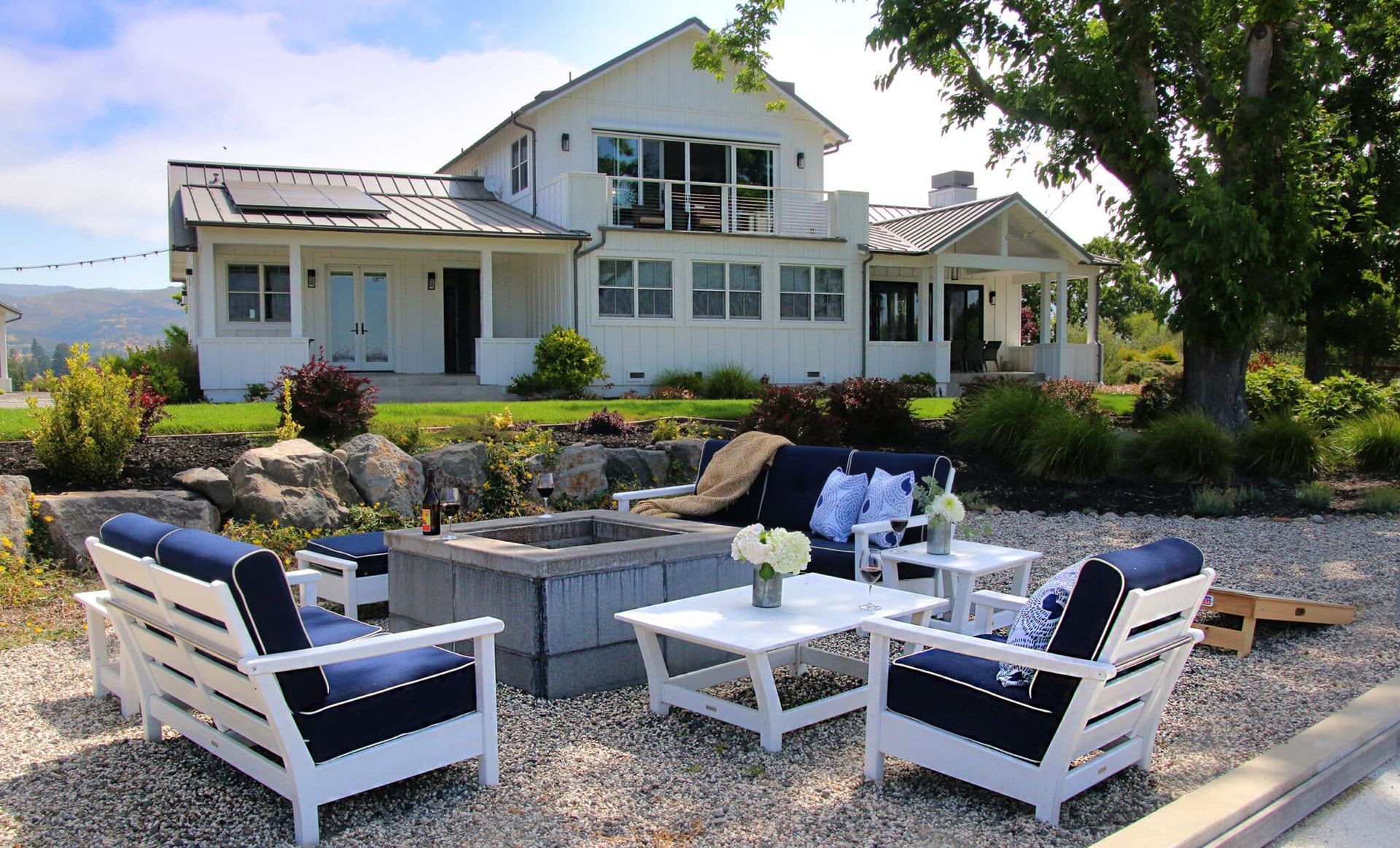 A white house with a fire pit in front of it