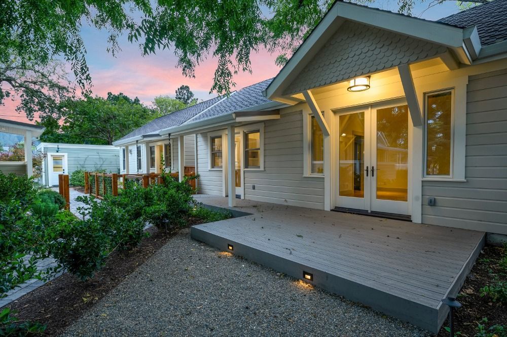 A house with a large deck and a sunset in the background