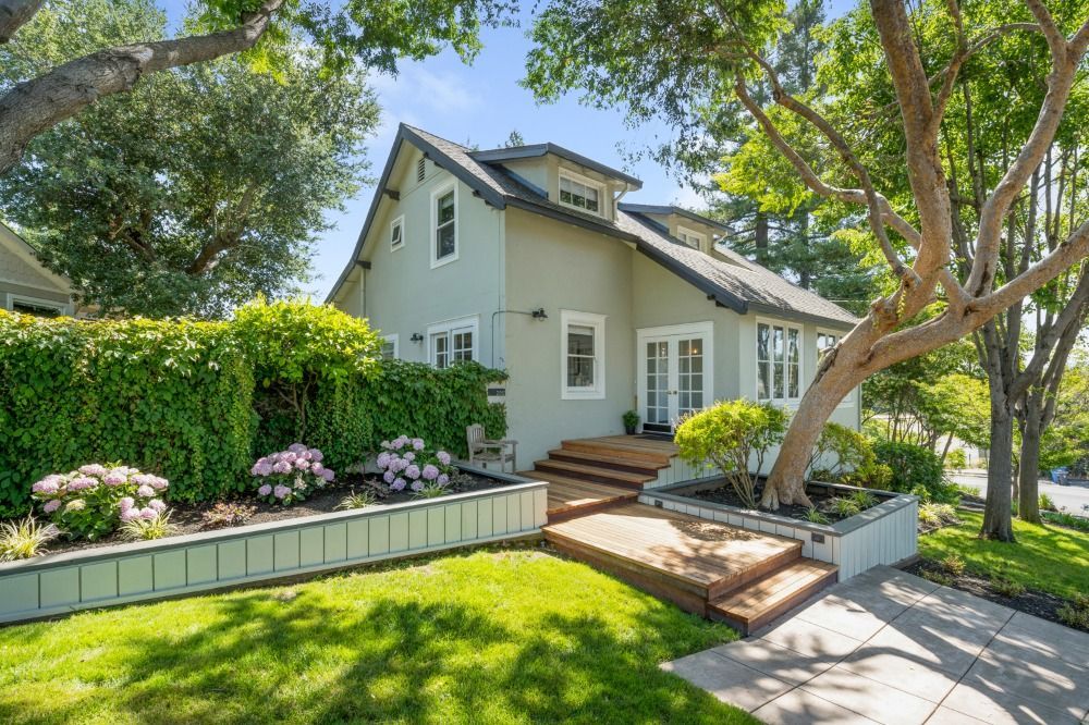 A house with a lush green lawn and trees in front of it.