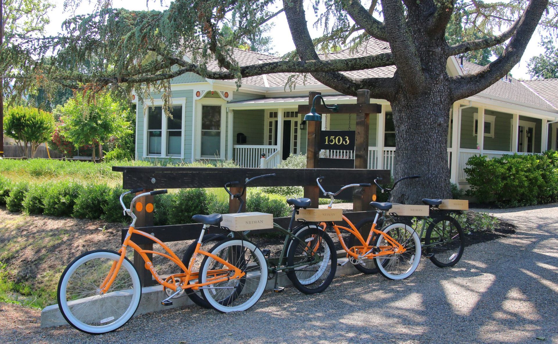 Three bicycles are parked in front of a house that says cali palette