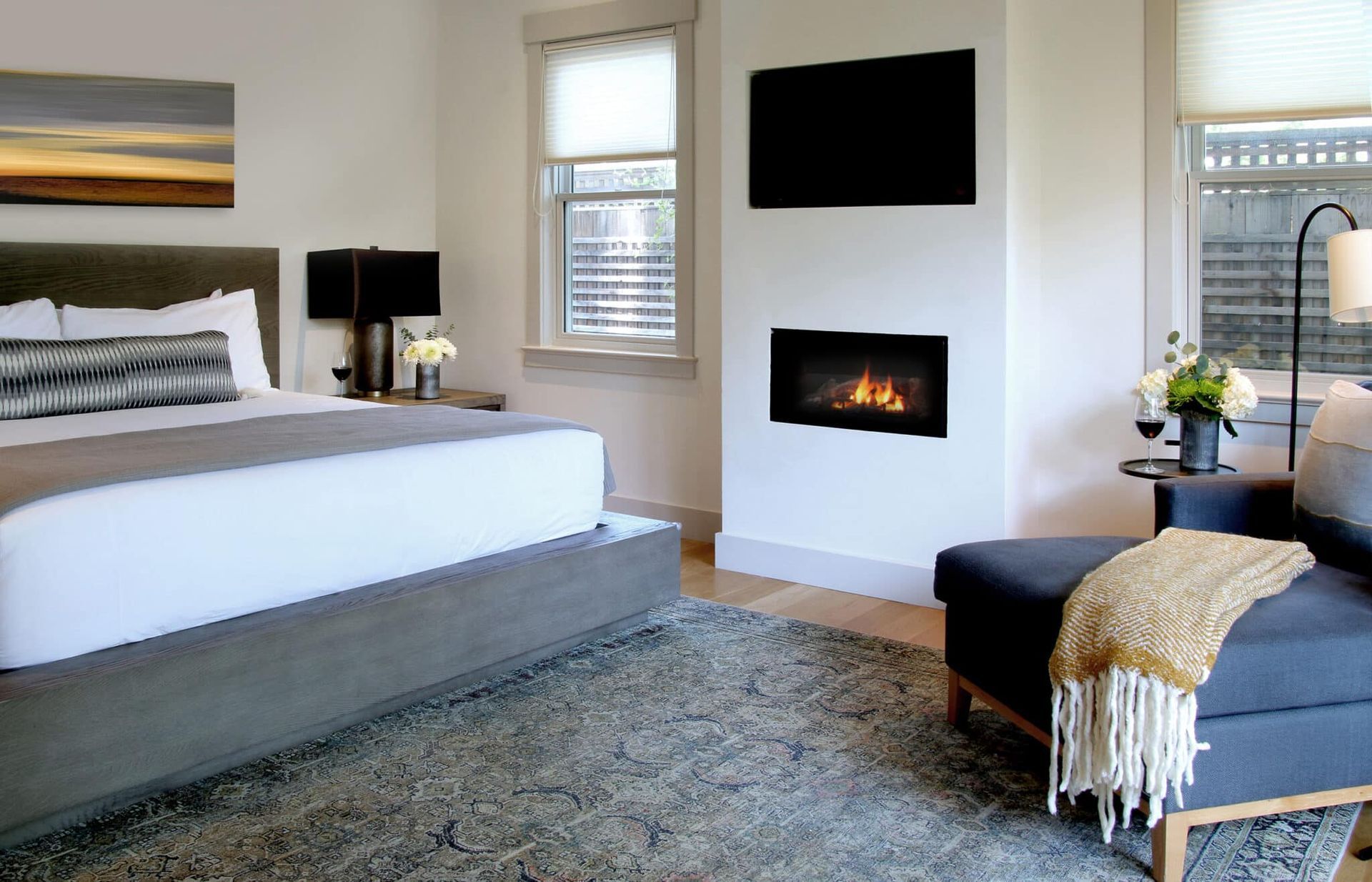 A bedroom with a fireplace and a large bed
