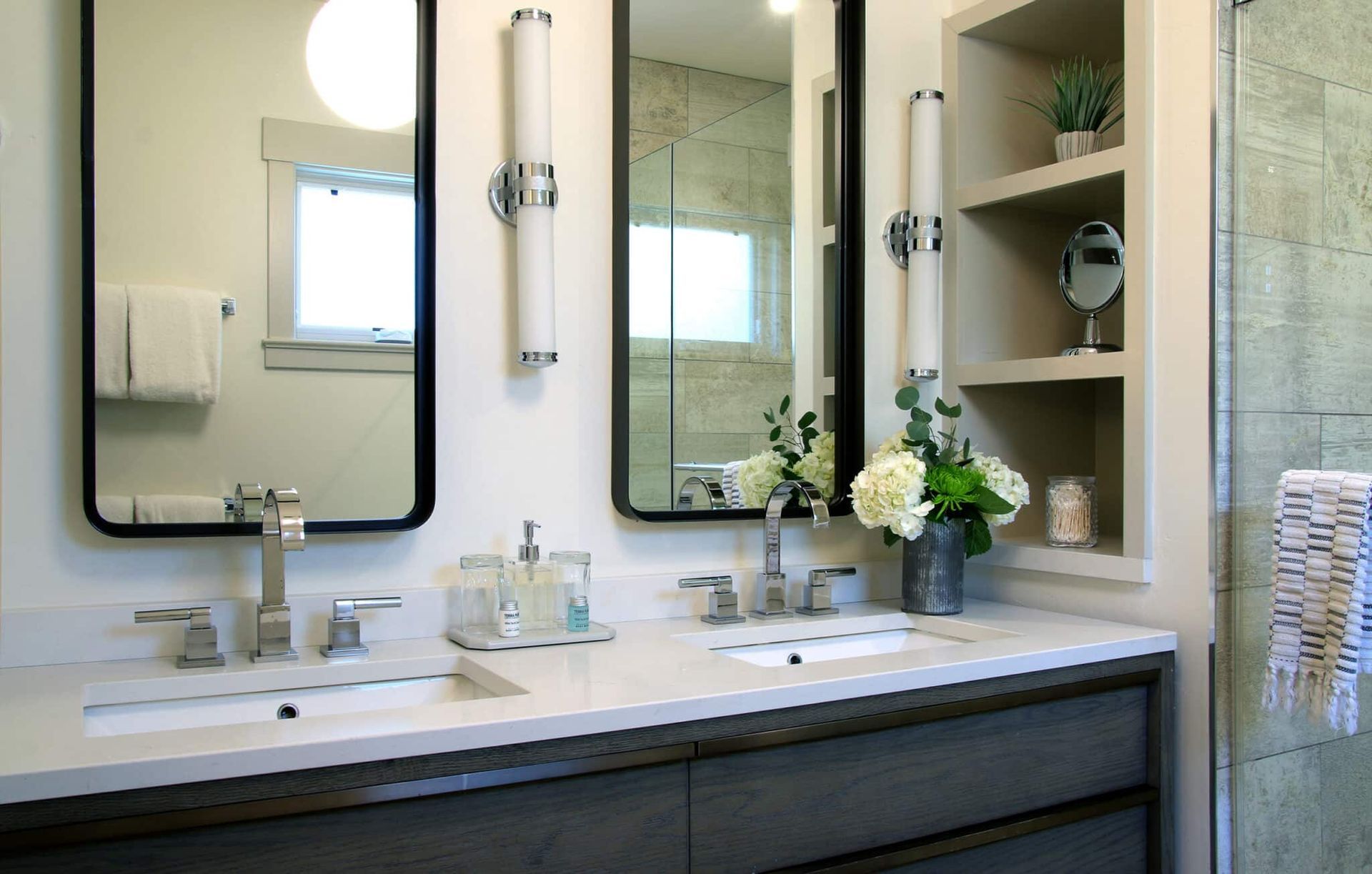 A bathroom with two sinks and two mirrors.