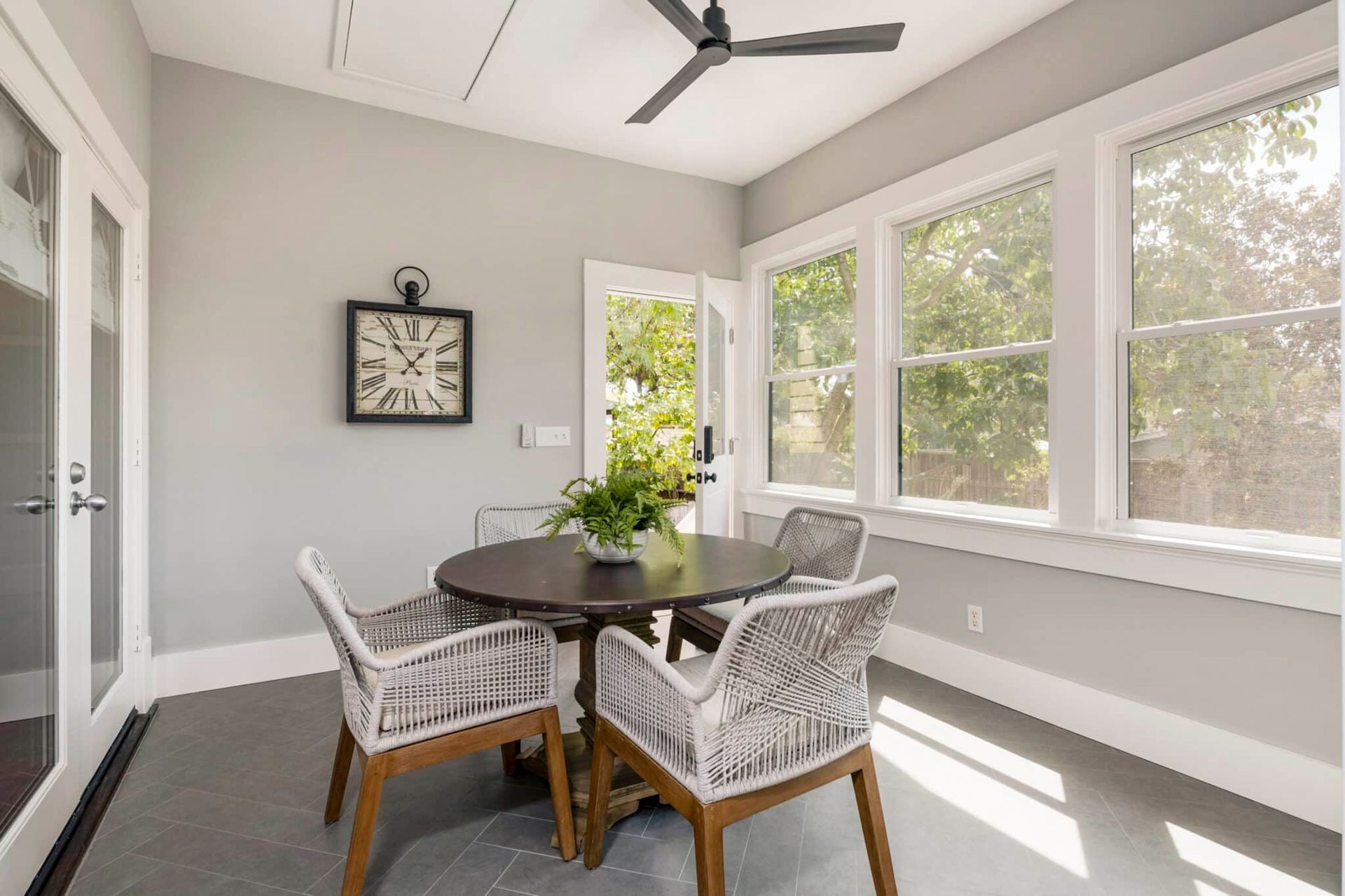 A dining room with a table and chairs and a ceiling fan.