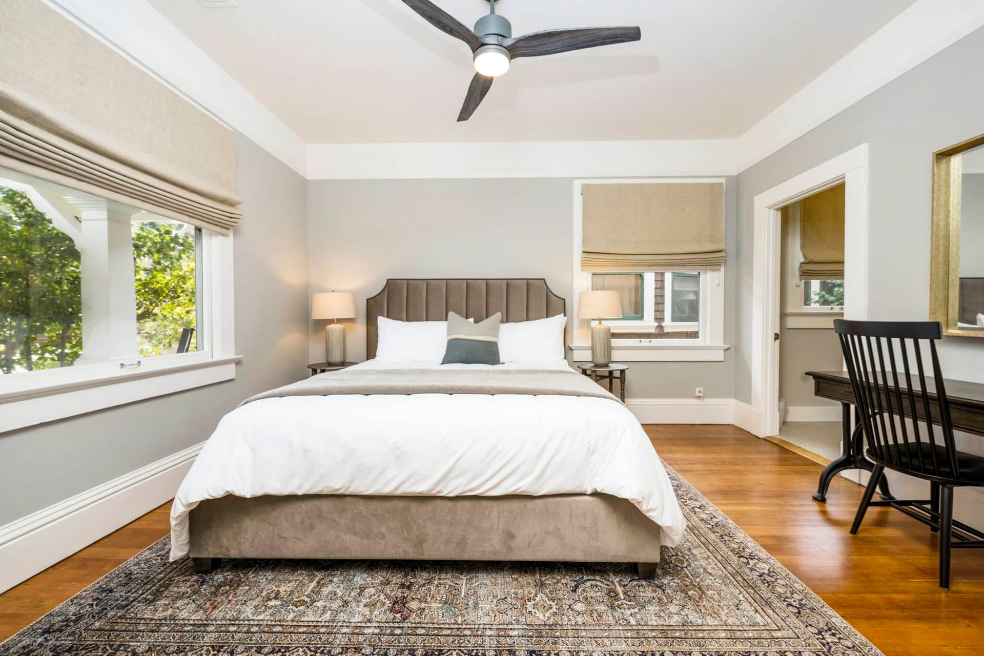 A bedroom with a large bed and a ceiling fan.