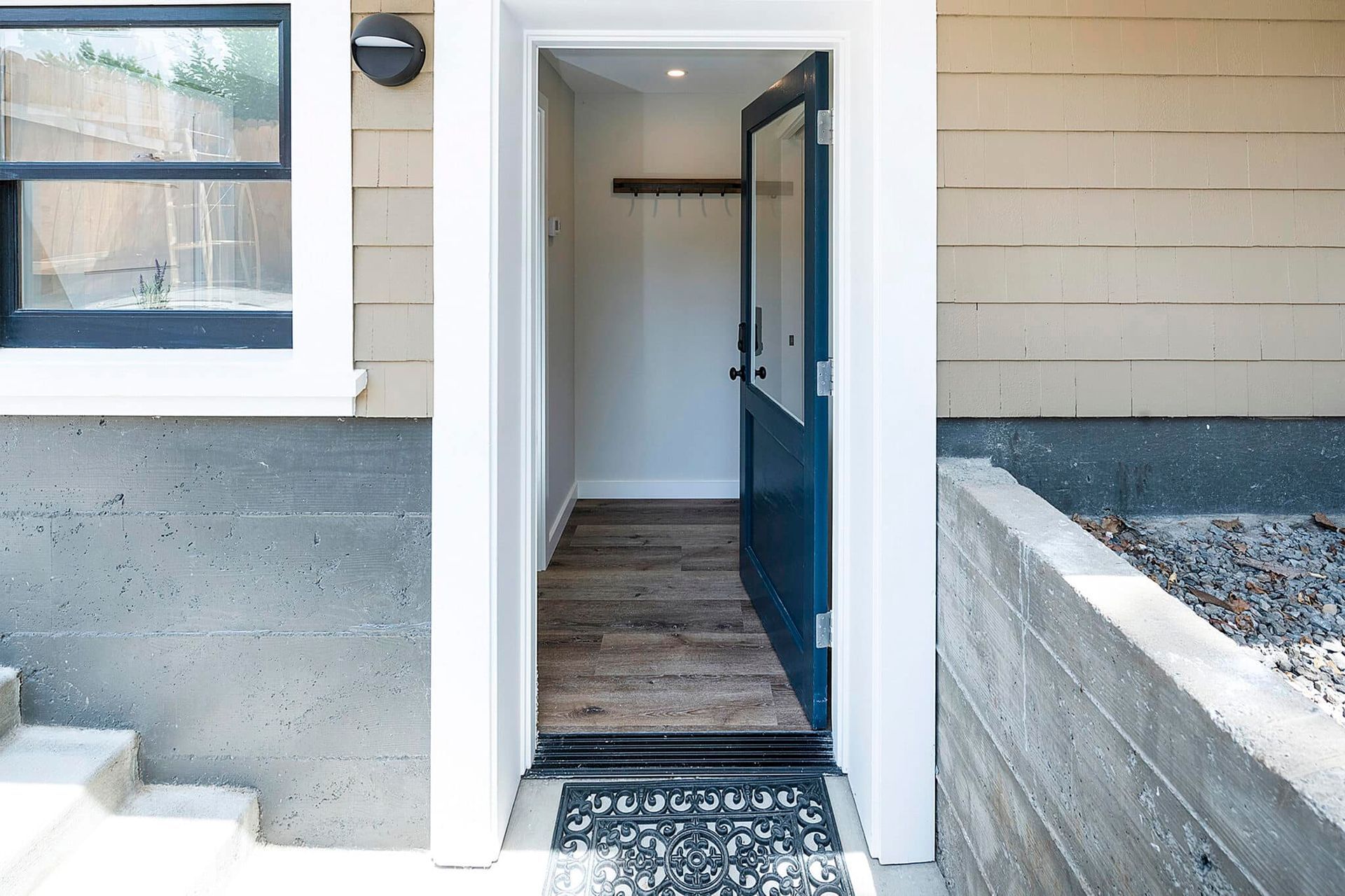 The front door of a house with a blue door and a window