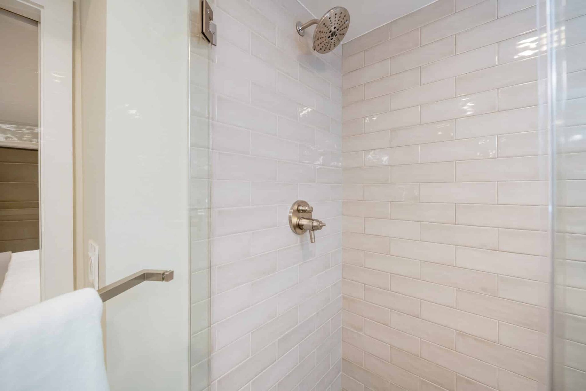 A bathroom with a walk in shower and a towel rack.