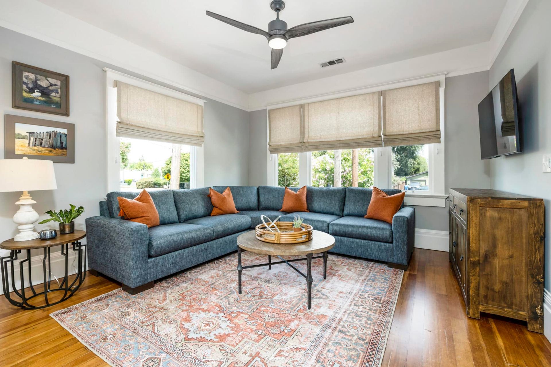 A living room with a large sectional couch , coffee table , and television.