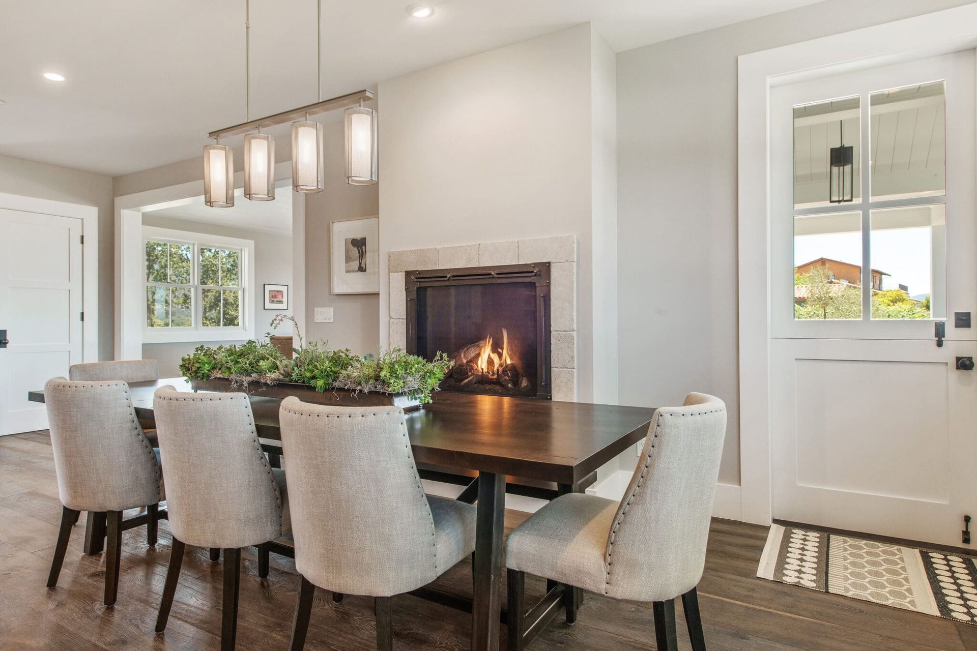 A dining room with a table and chairs and a fireplace.