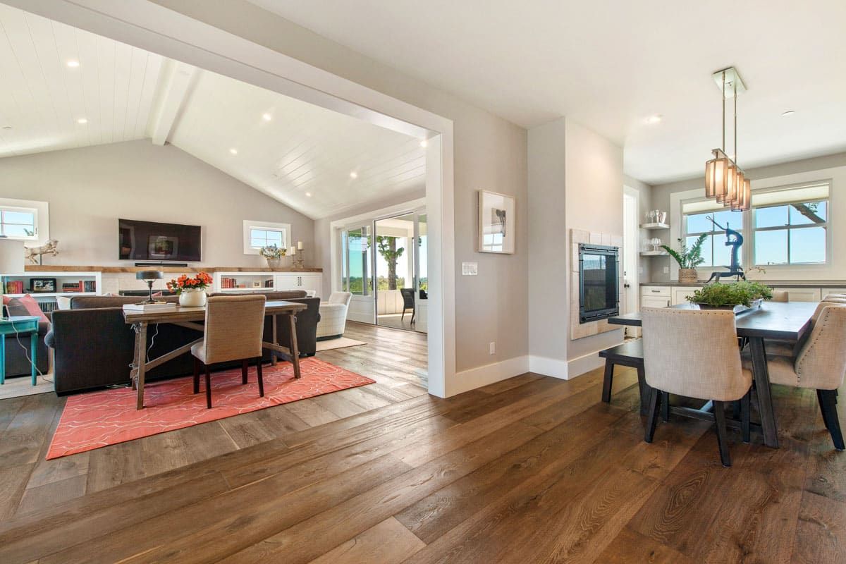 A living room and dining room in a house with hardwood floors.