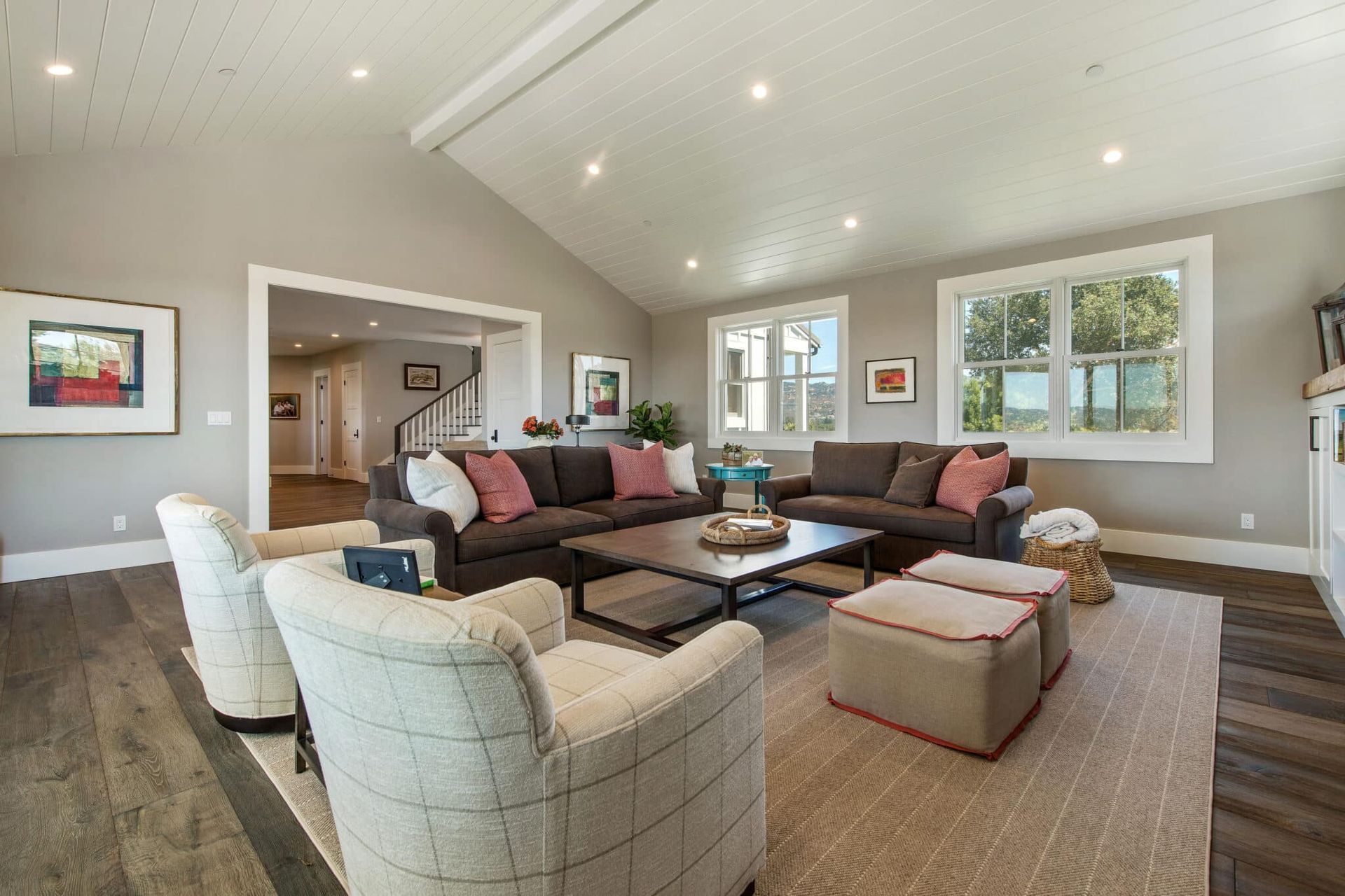 A living room filled with furniture and a vaulted ceiling.