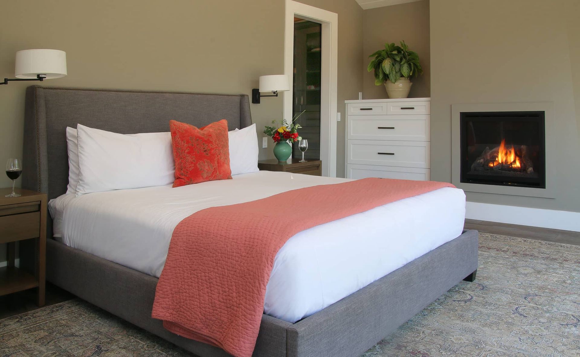 A bedroom with a king size bed and a fireplace.