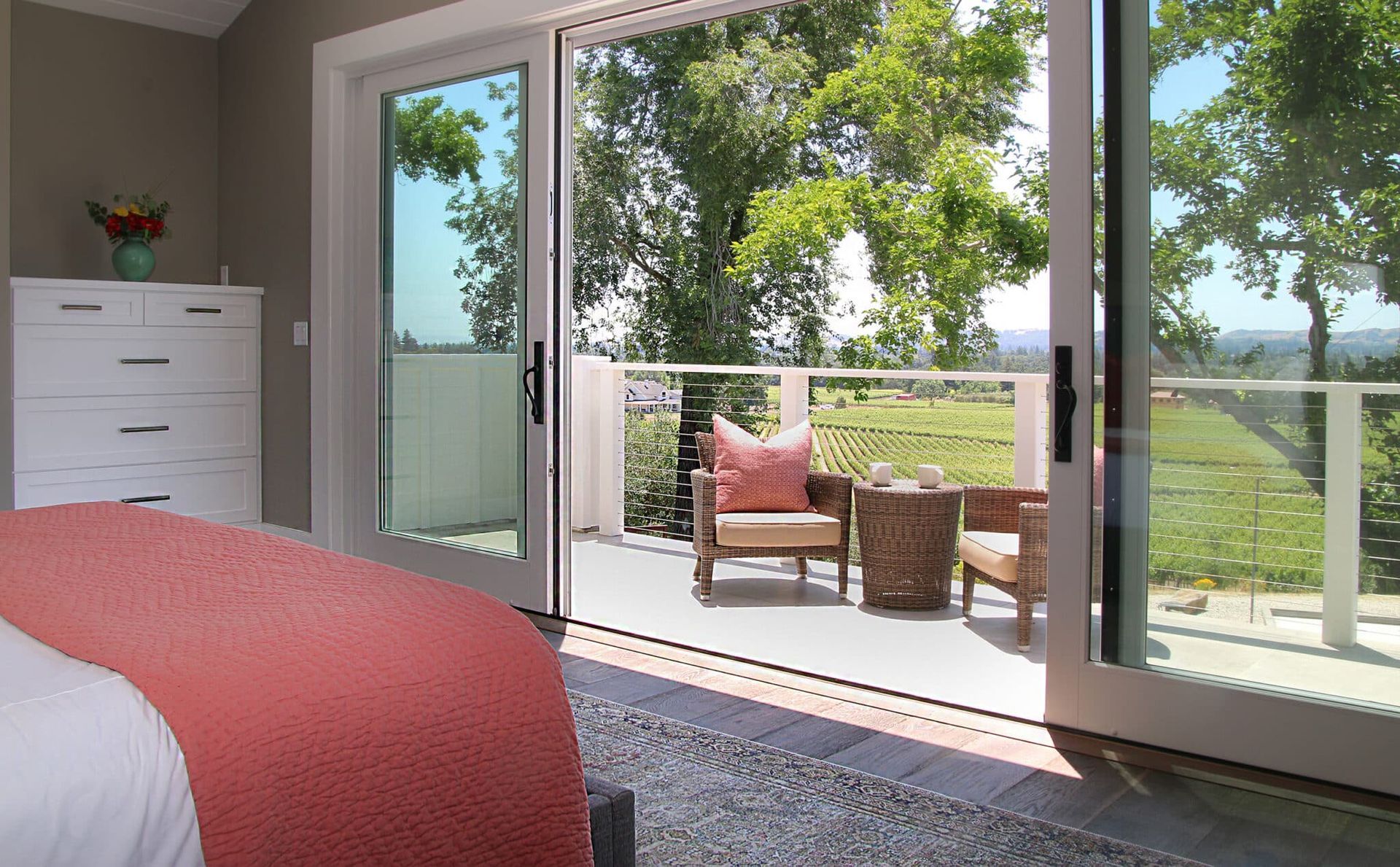 A bedroom with a sliding glass door leading to a balcony.