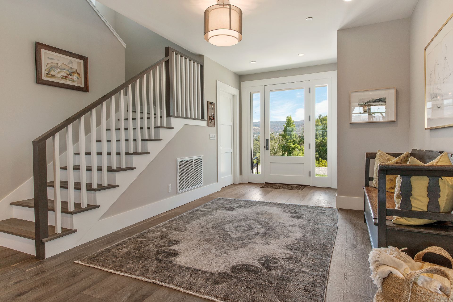 A hallway with stairs leading up to the second floor of a house.